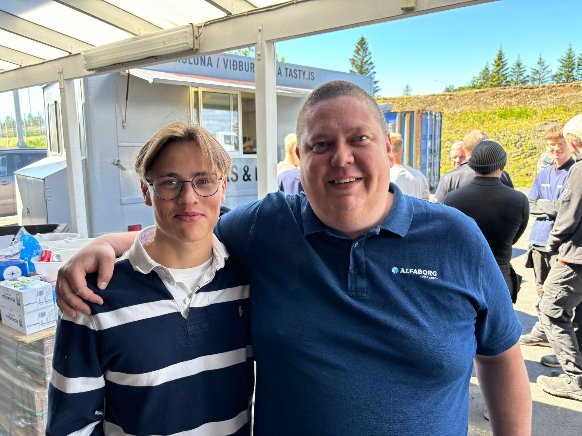 Karl og strákur sitja fyrir á mynd fyrir framan matarbíl.