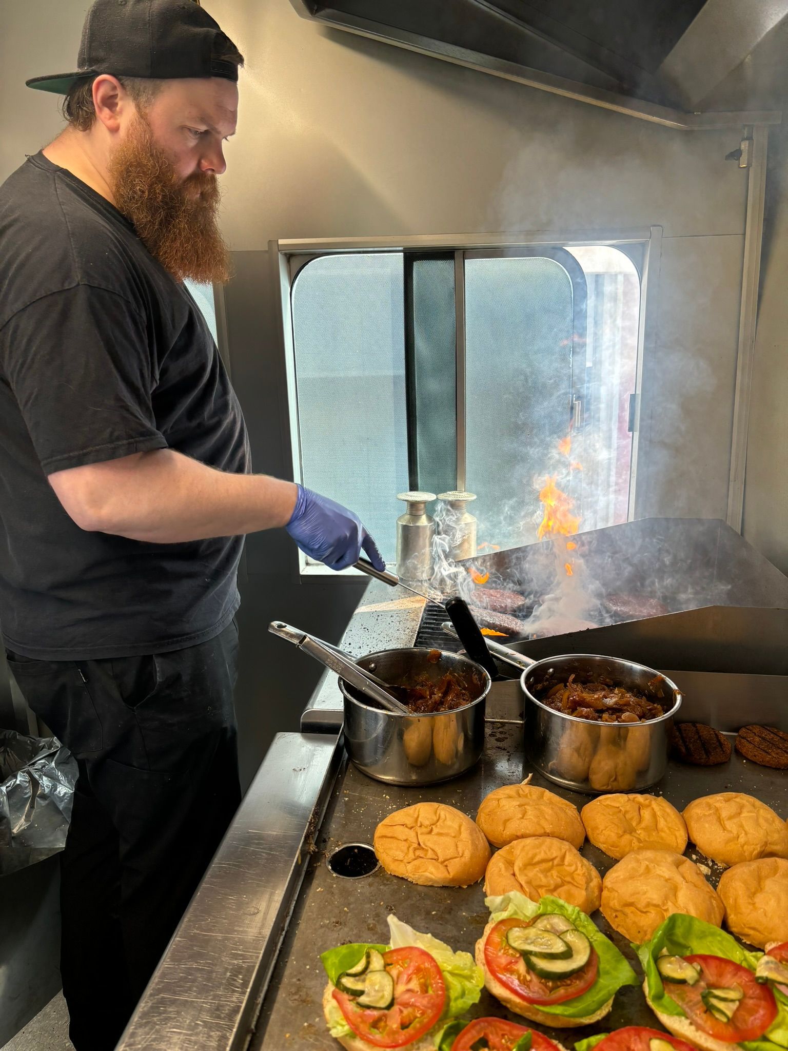 Maður er að elda mat á grilli í eldhúsi.