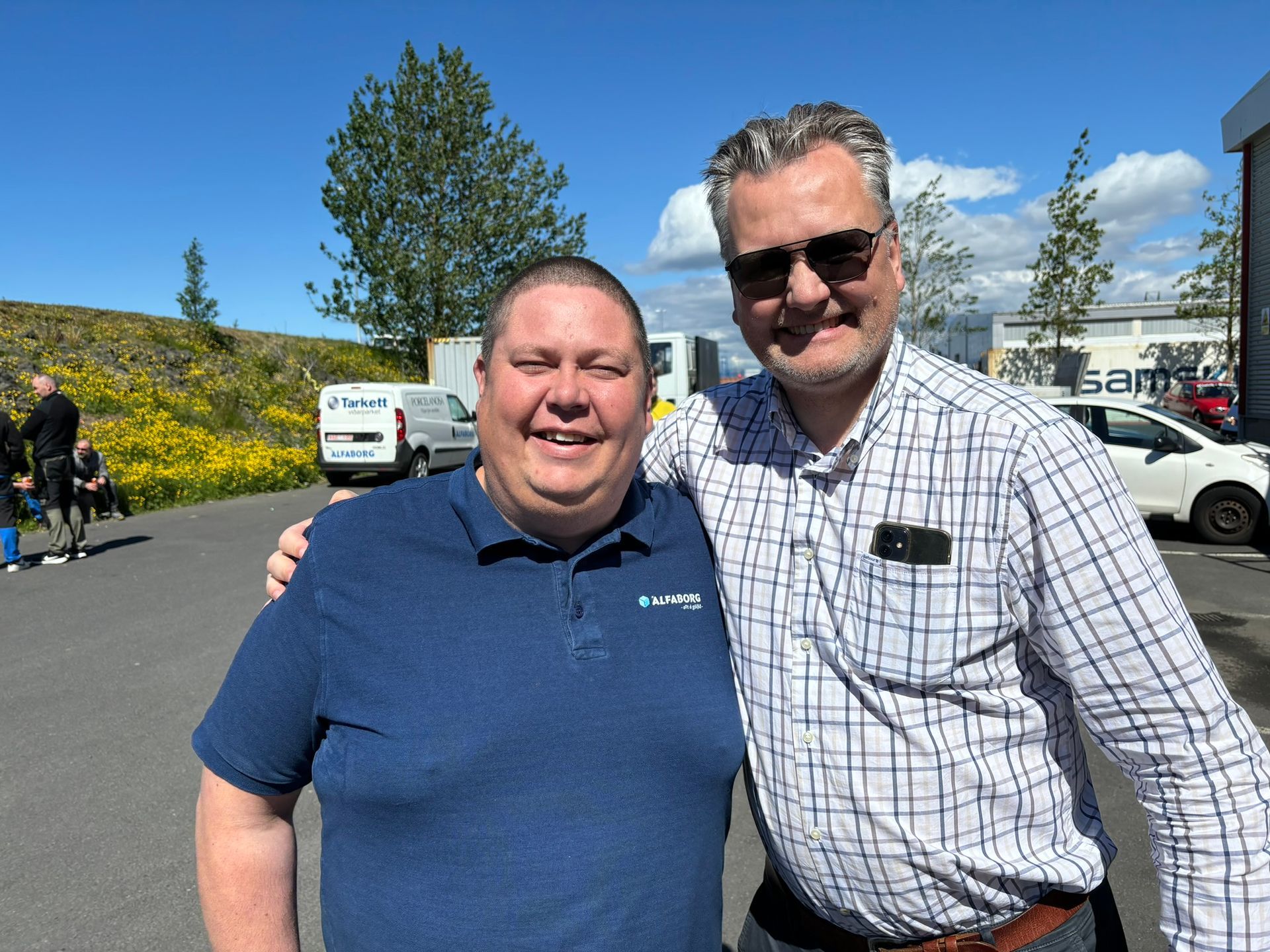 Tveir menn sitja fyrir á mynd á bílastæði