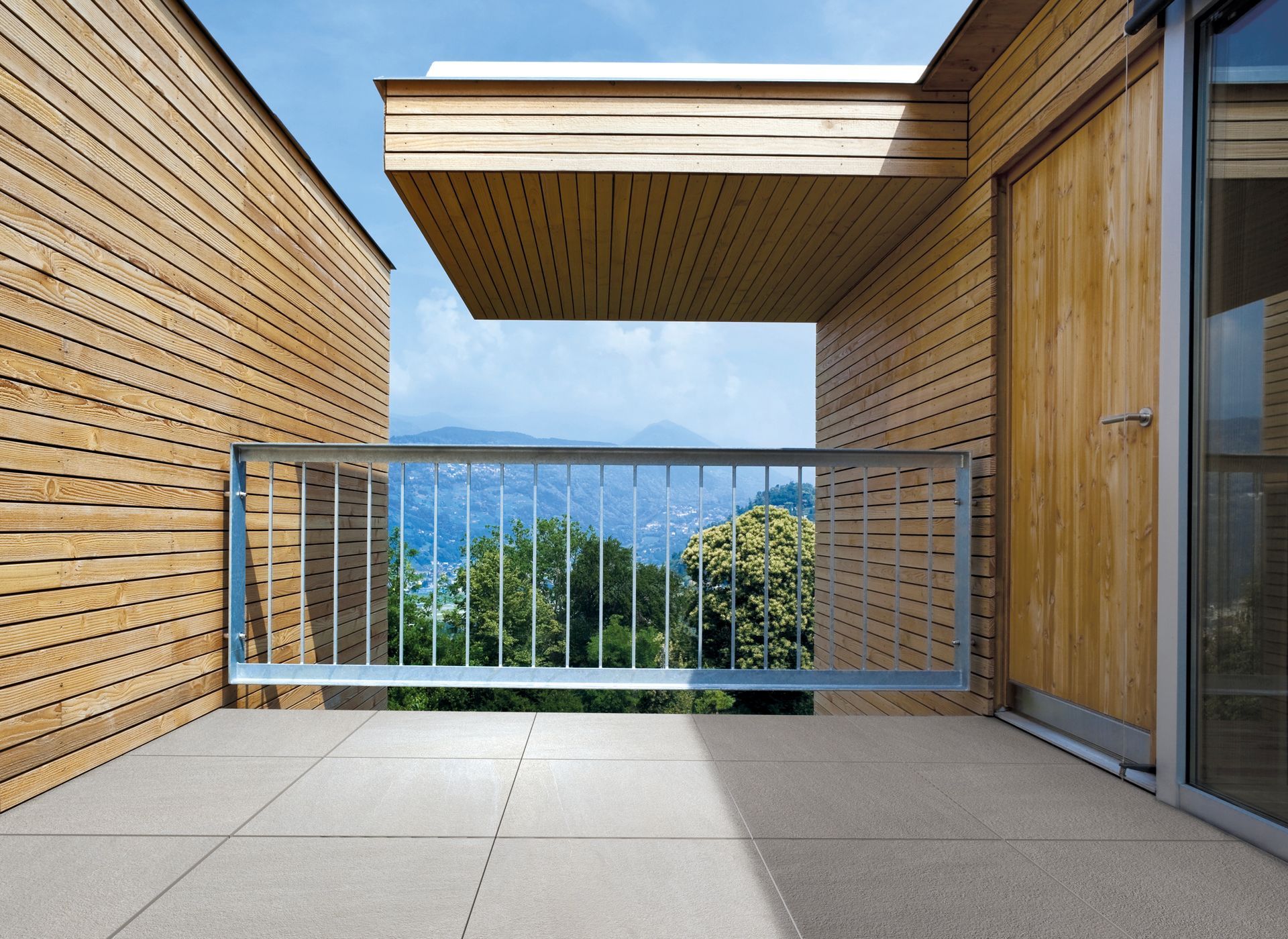 Svalir með málmhandriði og timburbyggingu í bakgrunni