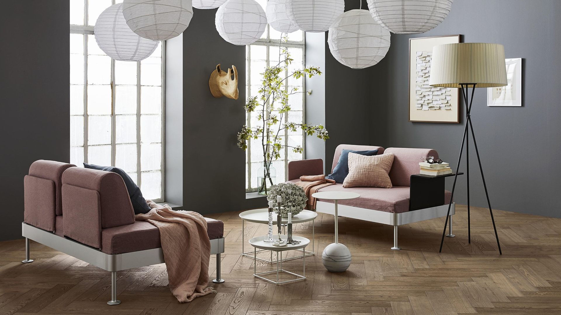 Stofa með sófa, borði, lampa og ljóskerum sem hanga í loftinu.