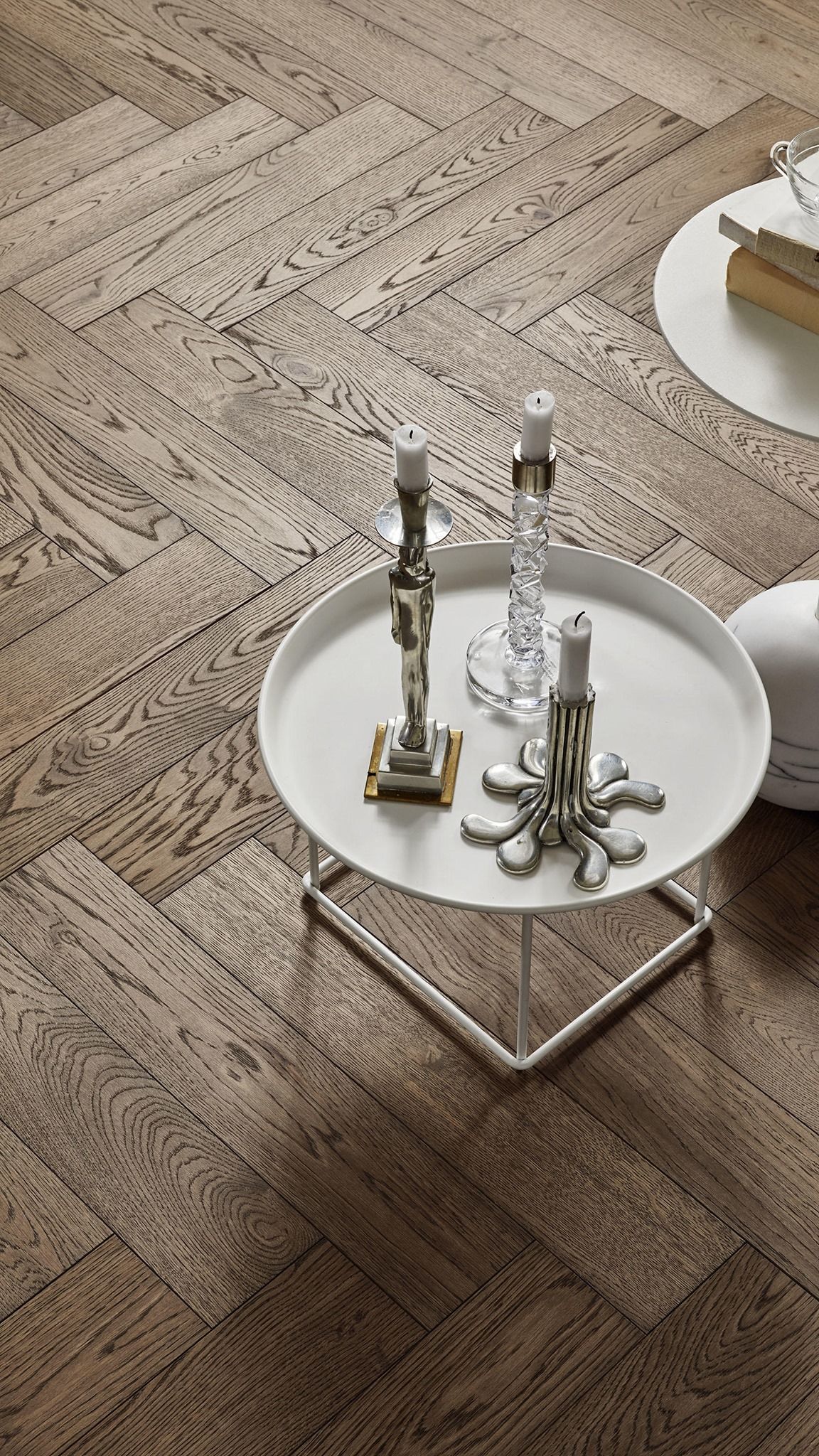 Hvítt borð með kertum á stendur á viðargólfi.