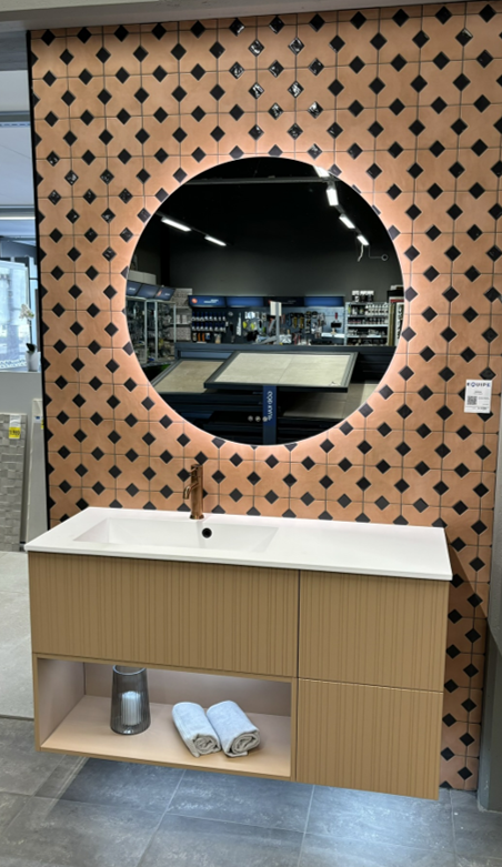 Baðherbergi með hringlaga spegli og vaski