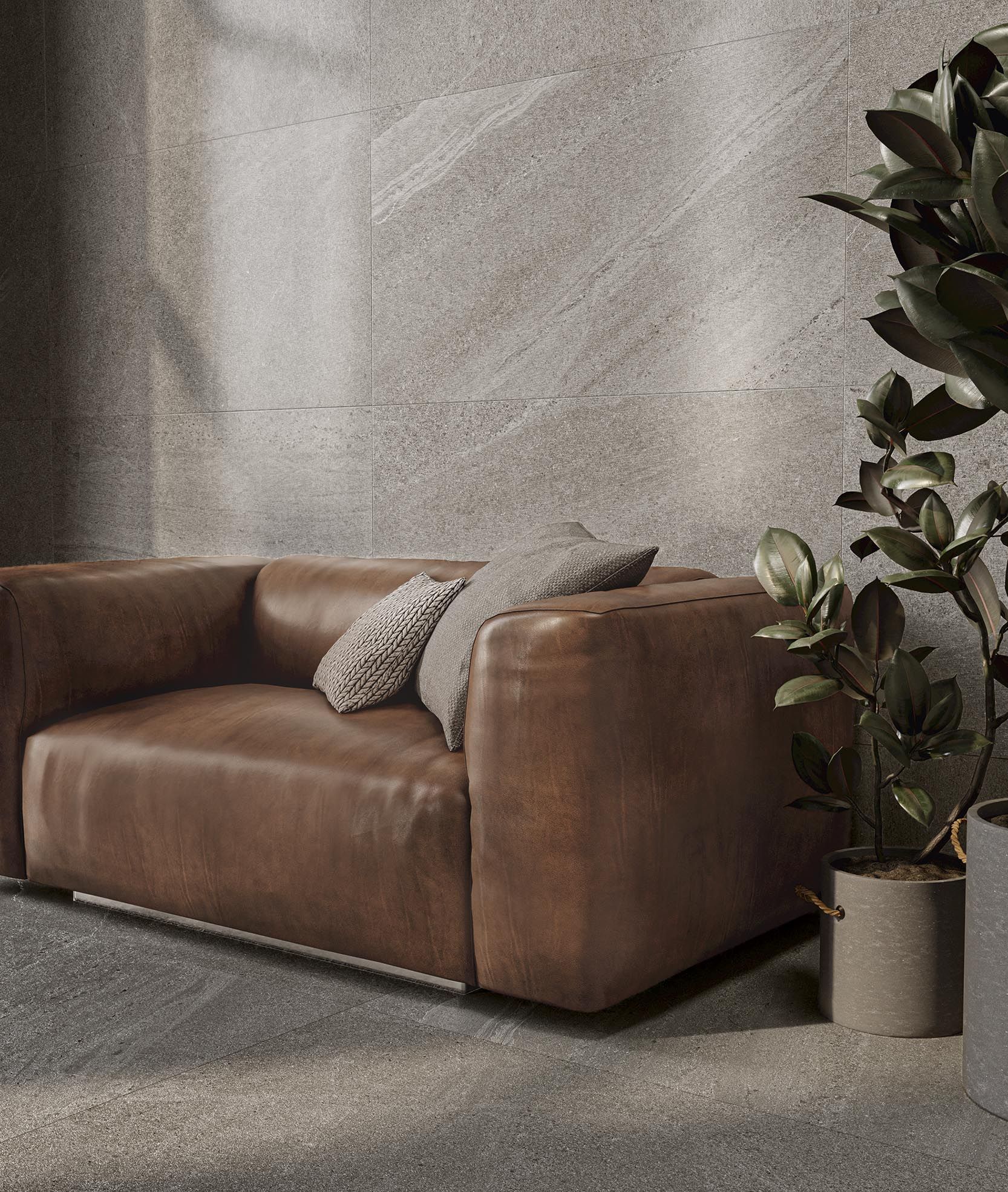 Brúnn leðursófi situr í stofu við hliðina á pottaplöntu.