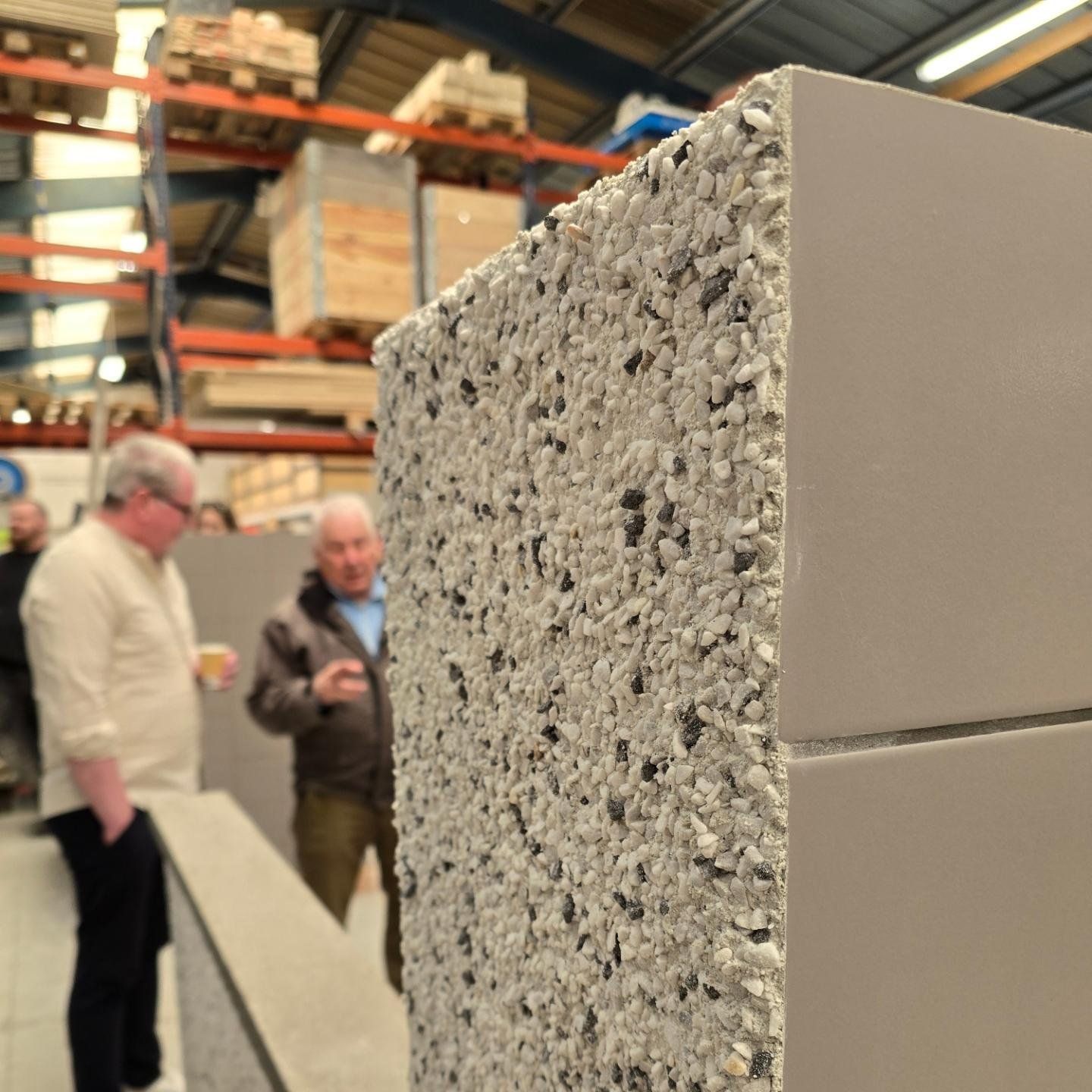 Hópur manna stendur í kringum steypublokk í vöruhúsi