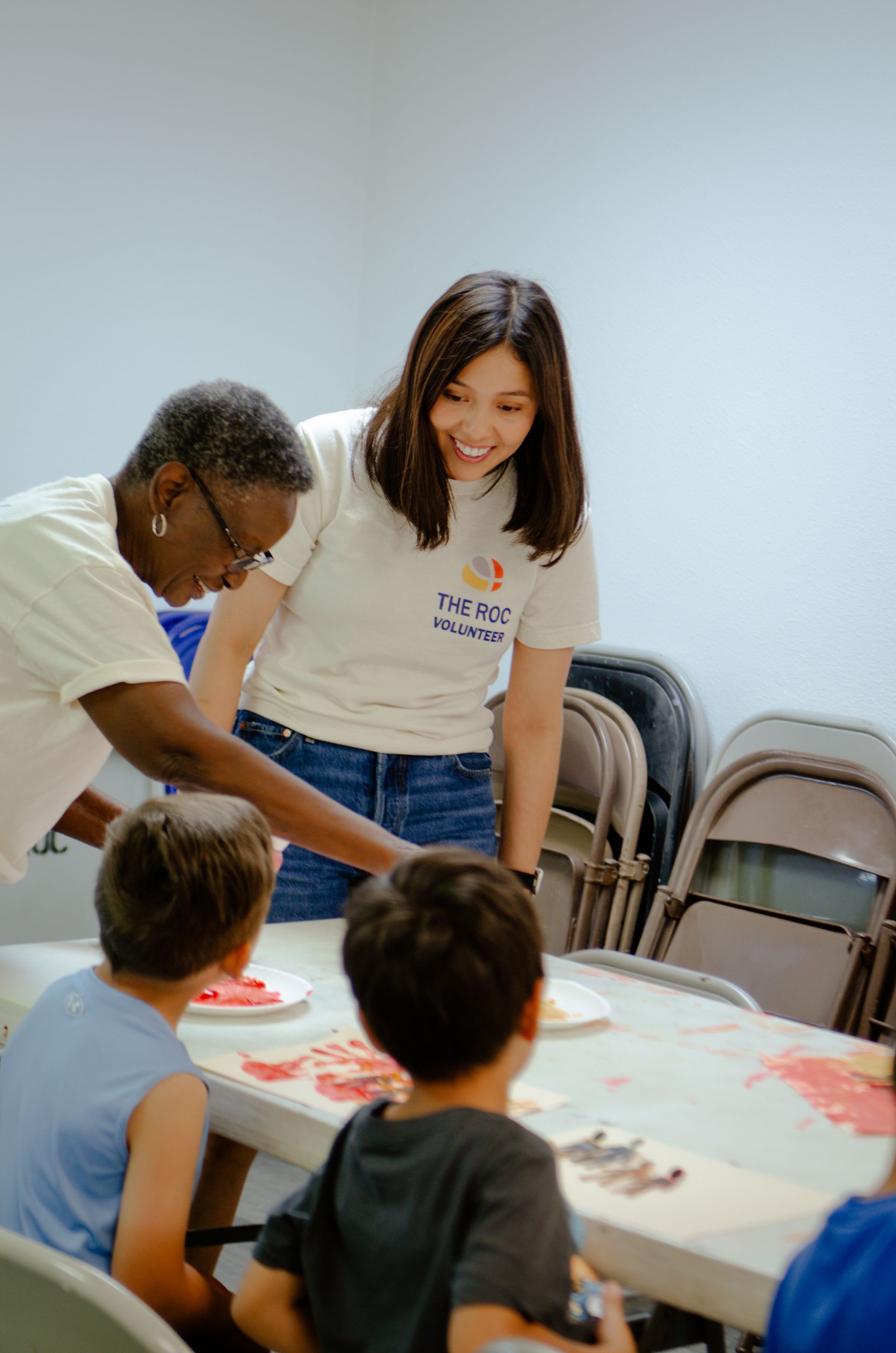 A woman is standing next to a man and two children at a table.