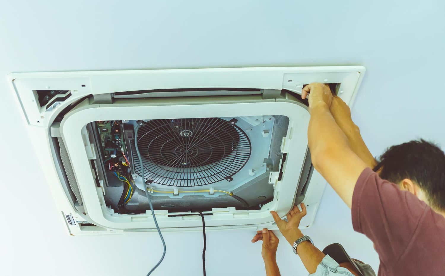 Black pergola with white curtains, two chairs, and small table on green grass.