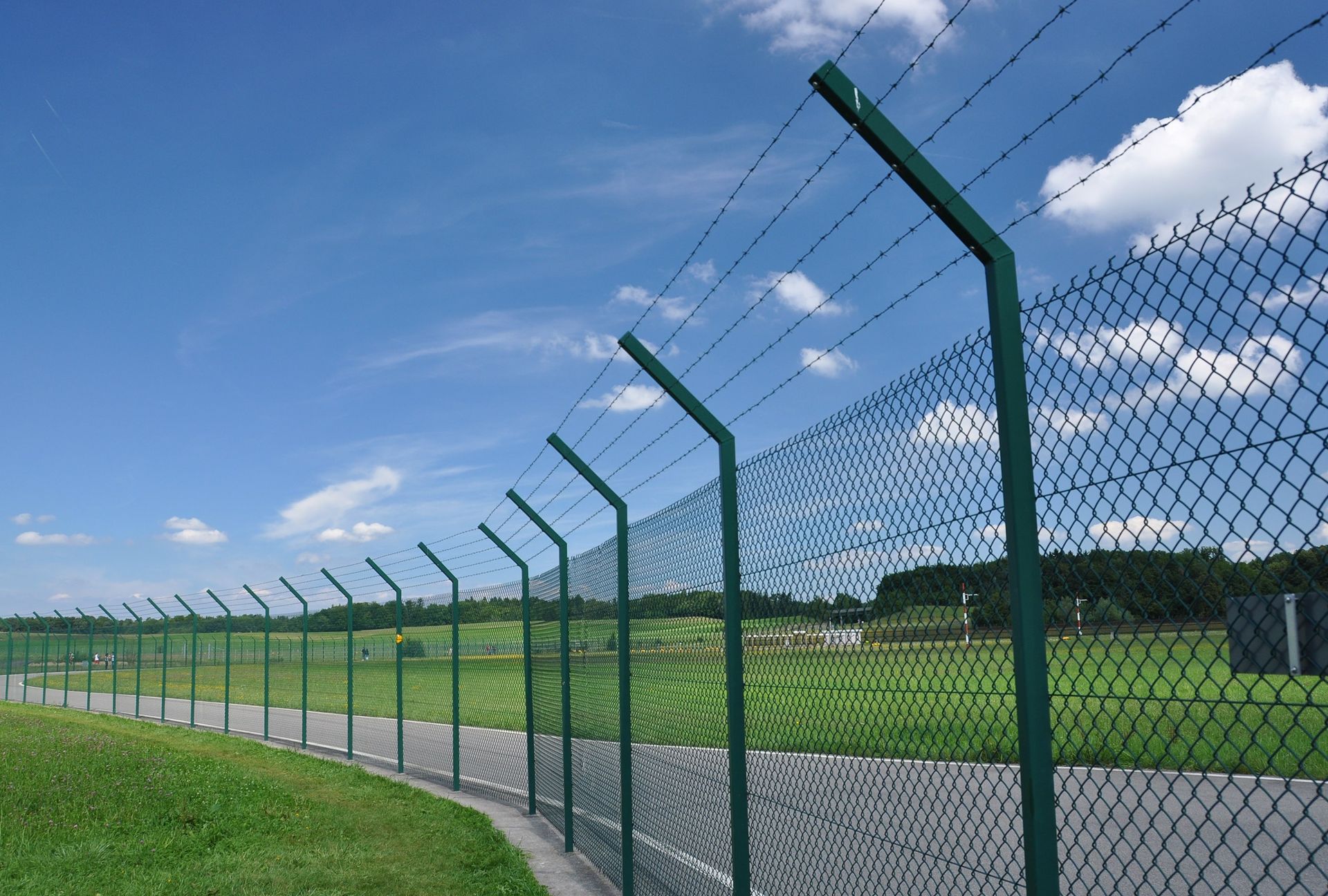 a chain link fence with barbed wire along the side of it