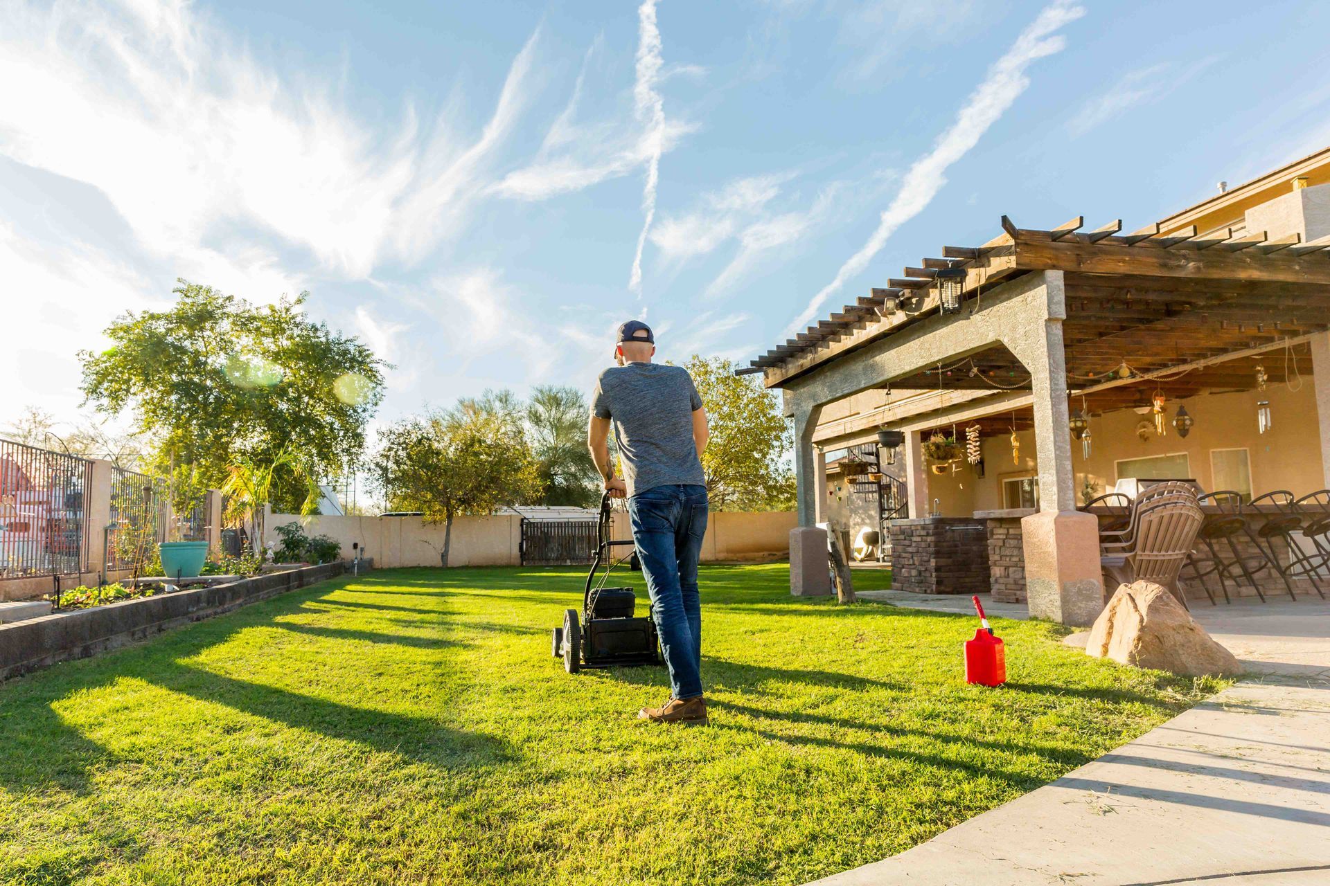 a man is using a lawn mower to cut the grass in his backyard