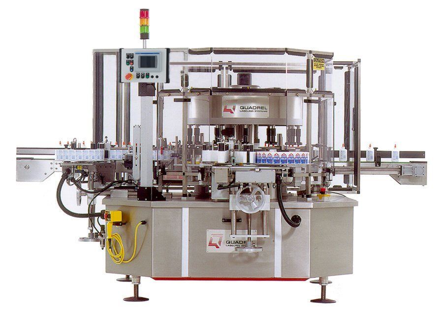 An industrial rotary labeling machine made of stainless steel with a conveyor belt system and a digital control panel.
