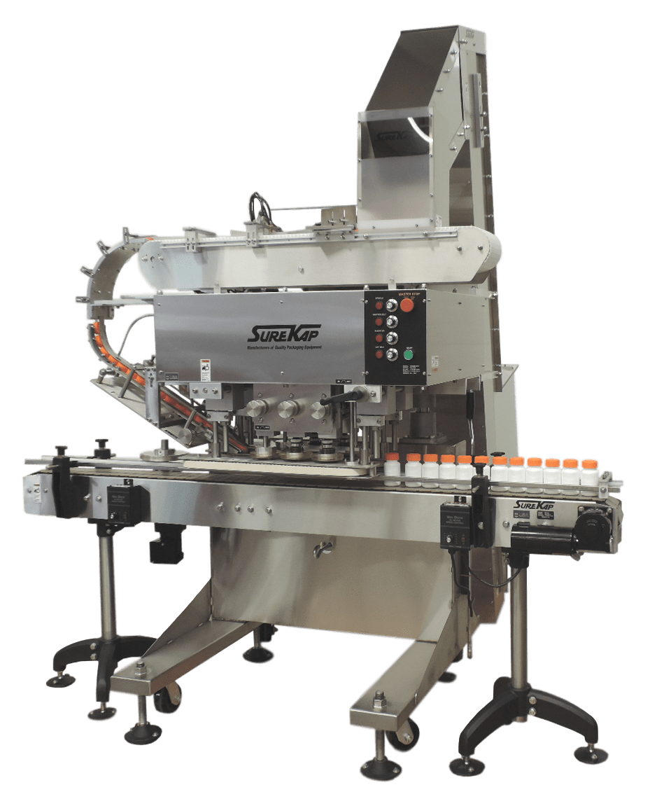 Industrial bottle capping machine on a conveyor belt with a silver metal frame and overhead cap-feeding chute.