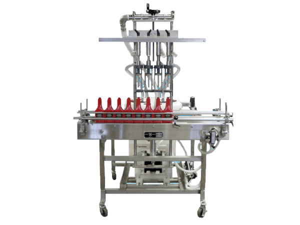 A stainless steel industrial liquid filling machine with a line of red bottles on a conveyor belt.