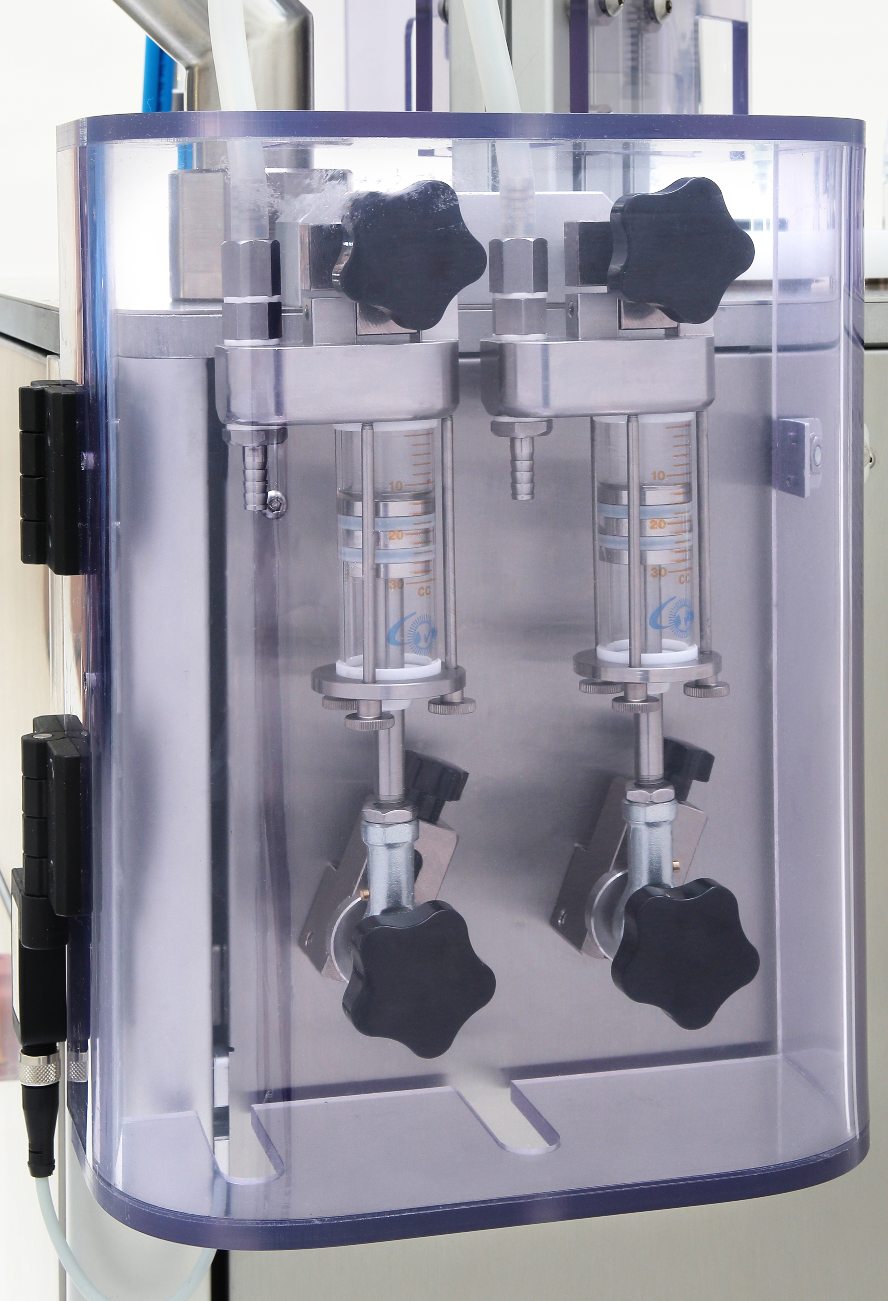 Two vertical clear pump cylinders.