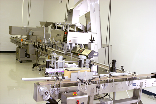 A stainless steel industrial packaging or bottling assembly line machine in a clean.