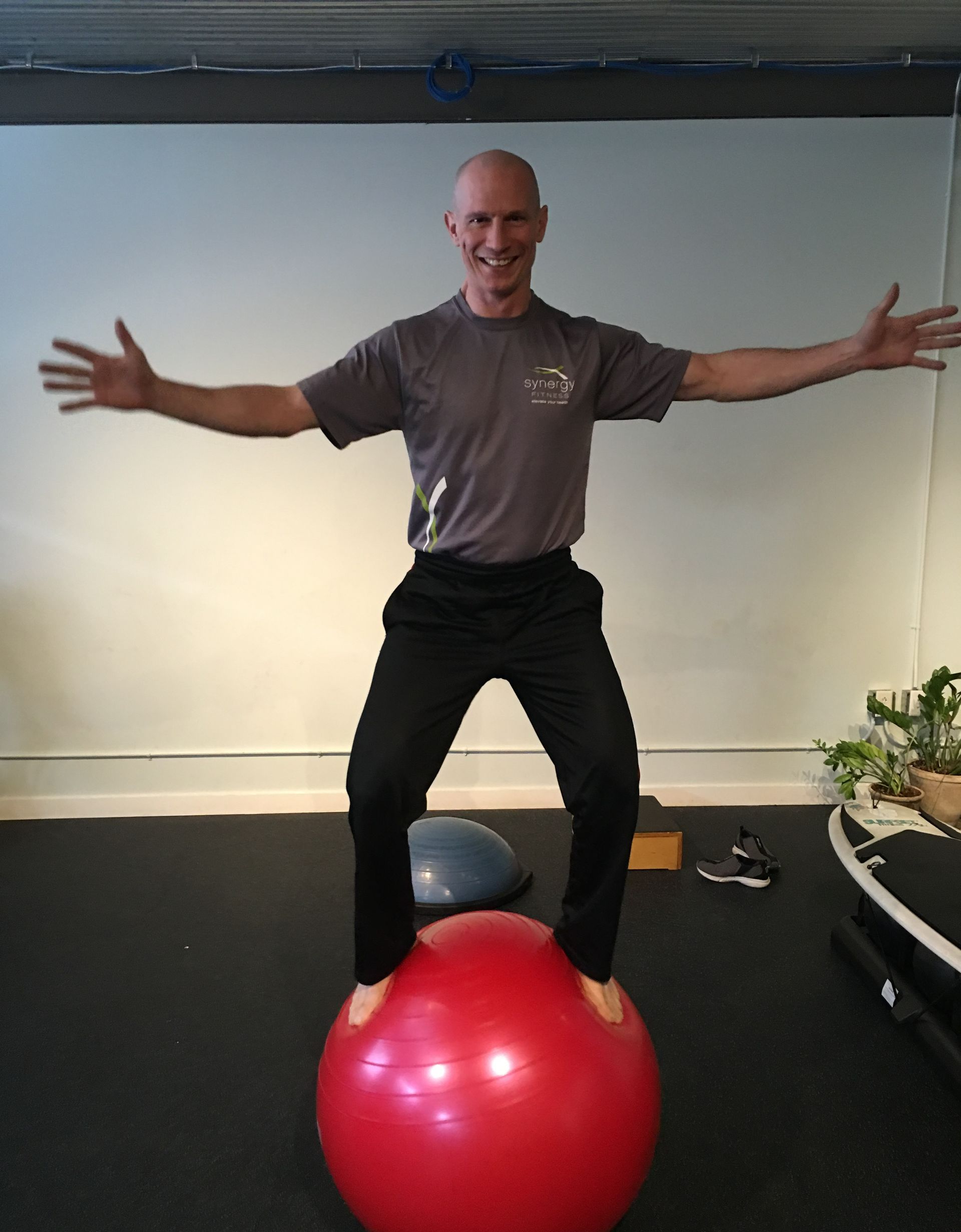 A man is doing a yoga pose on a surfboard.