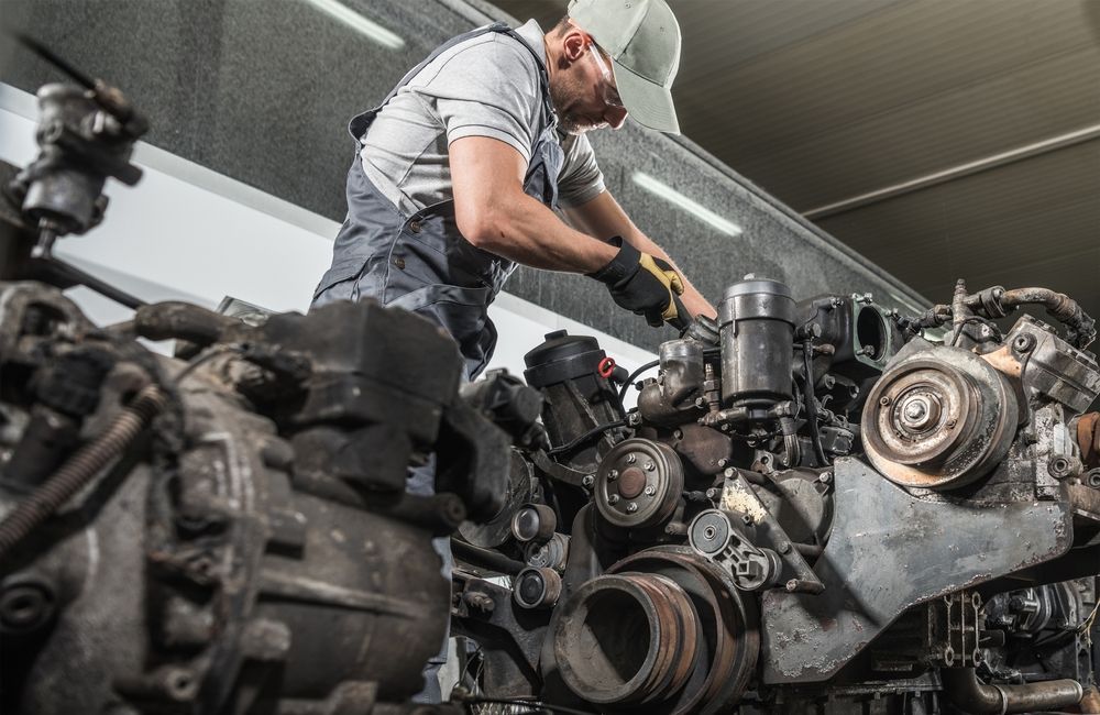 A man is working on a car engine in a garage.