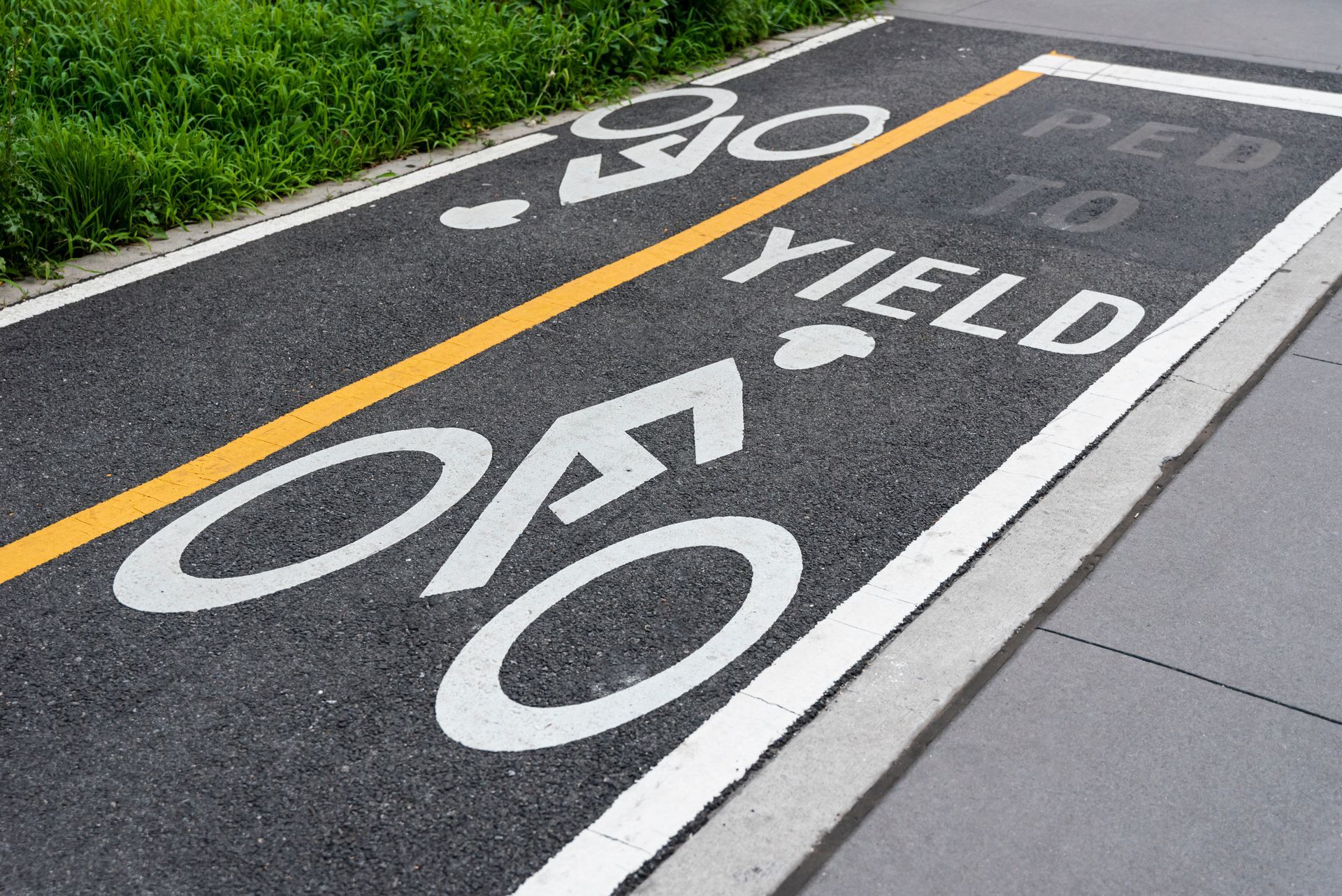 Bike lane with a yellow line, bicycle symbols, and