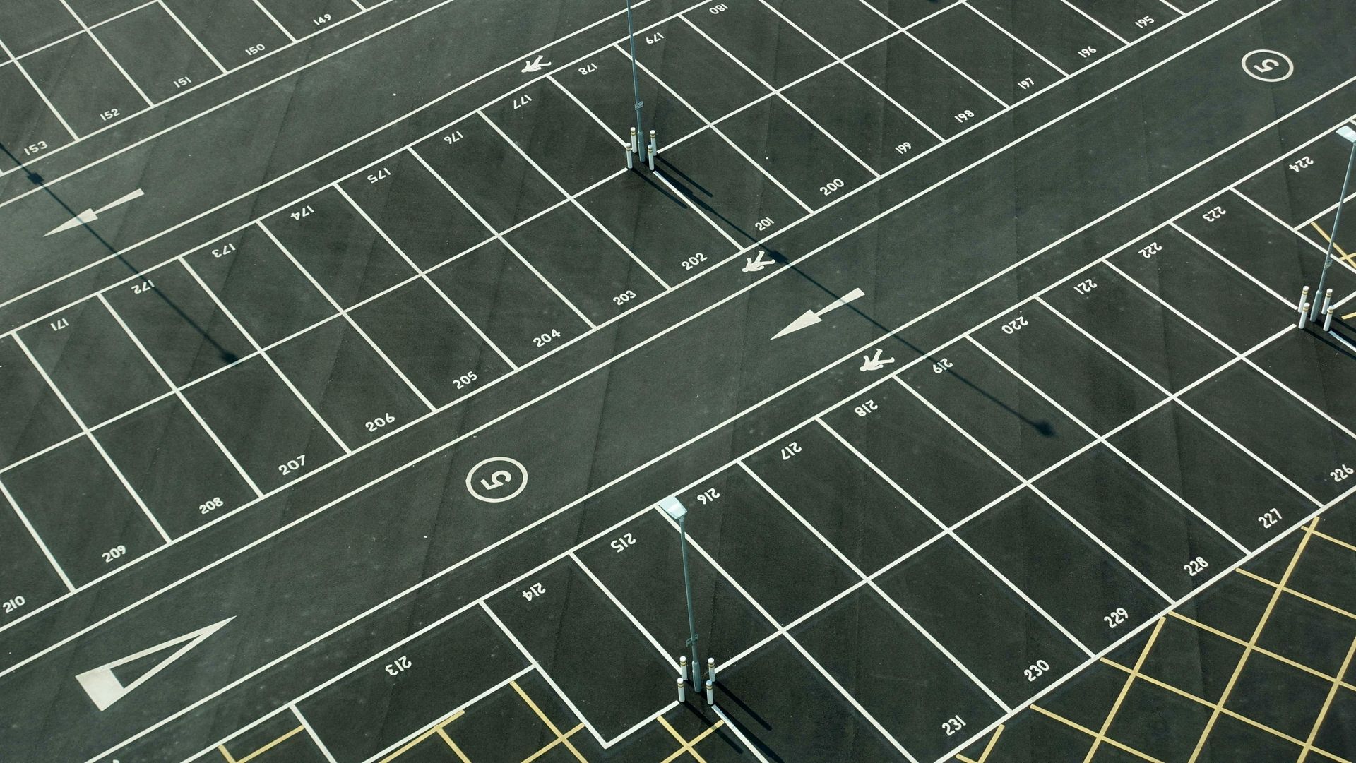 An aerial view of an empty parking lot with the number 5 in the middle