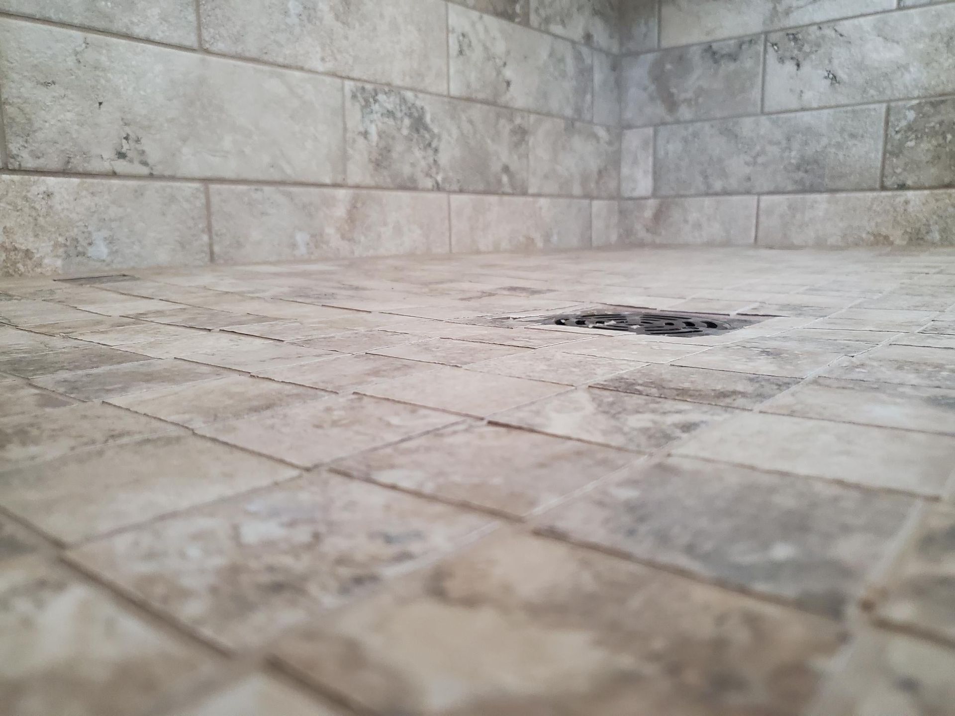A close up of a tiled shower floor by Floor Source