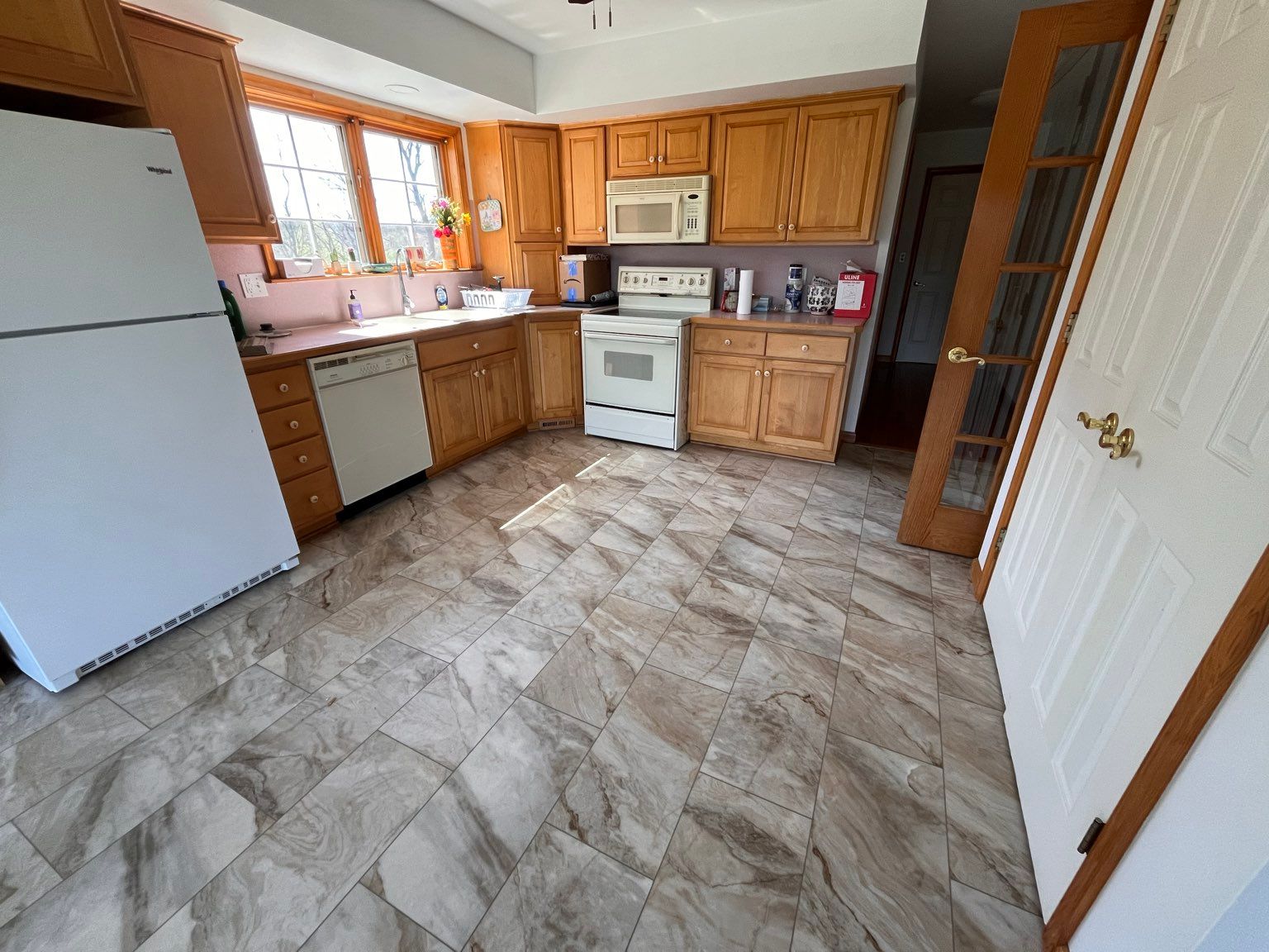 A kitchen with wooden cabinets and new flooring installed by Floor Source