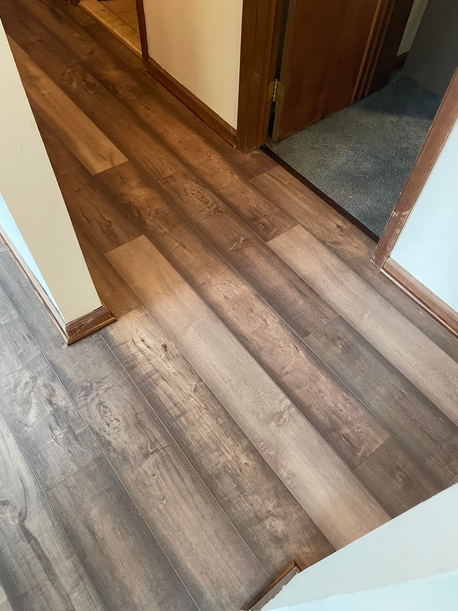 A hallway with a wooden floor installed by Floor Source and stairs leading to a bathroom.