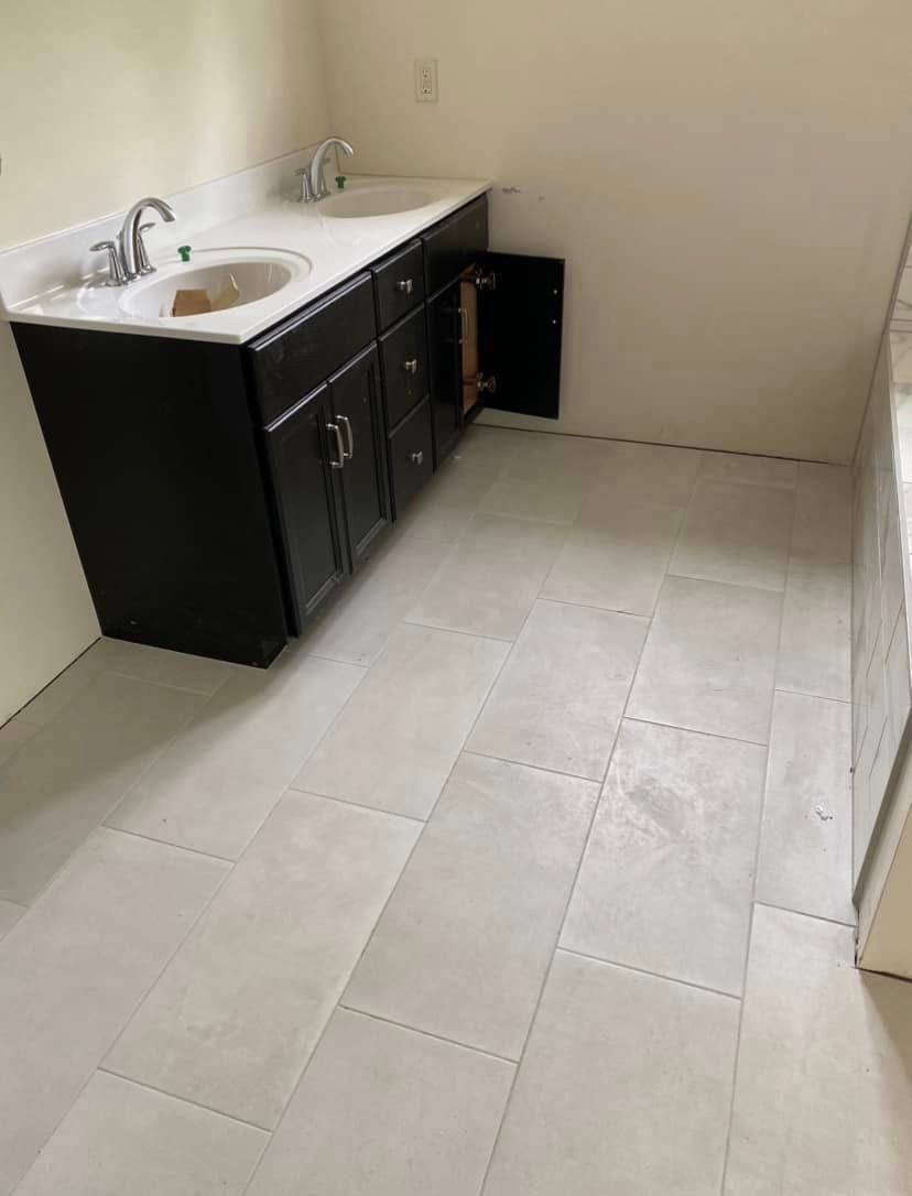 A bathroom with a sink , cabinets , and tile floor by Floor Source