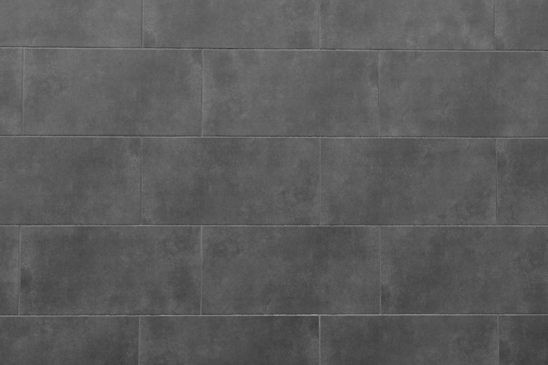 A close up of a gray tile wall.