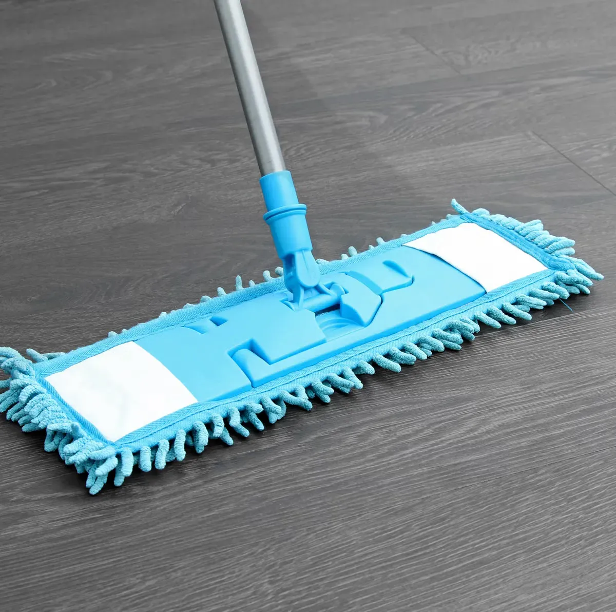 A blue mop is sitting on a wooden floor