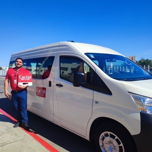 a man in a red shirt is standing next to a white van that says cargo