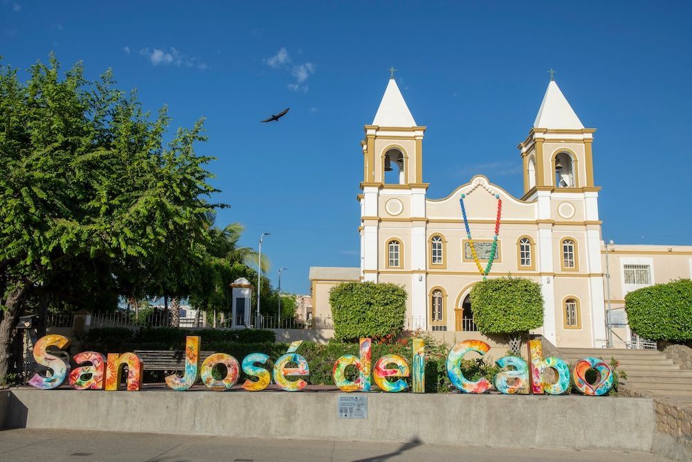 a sign that says san jose del cabo in front of a church .