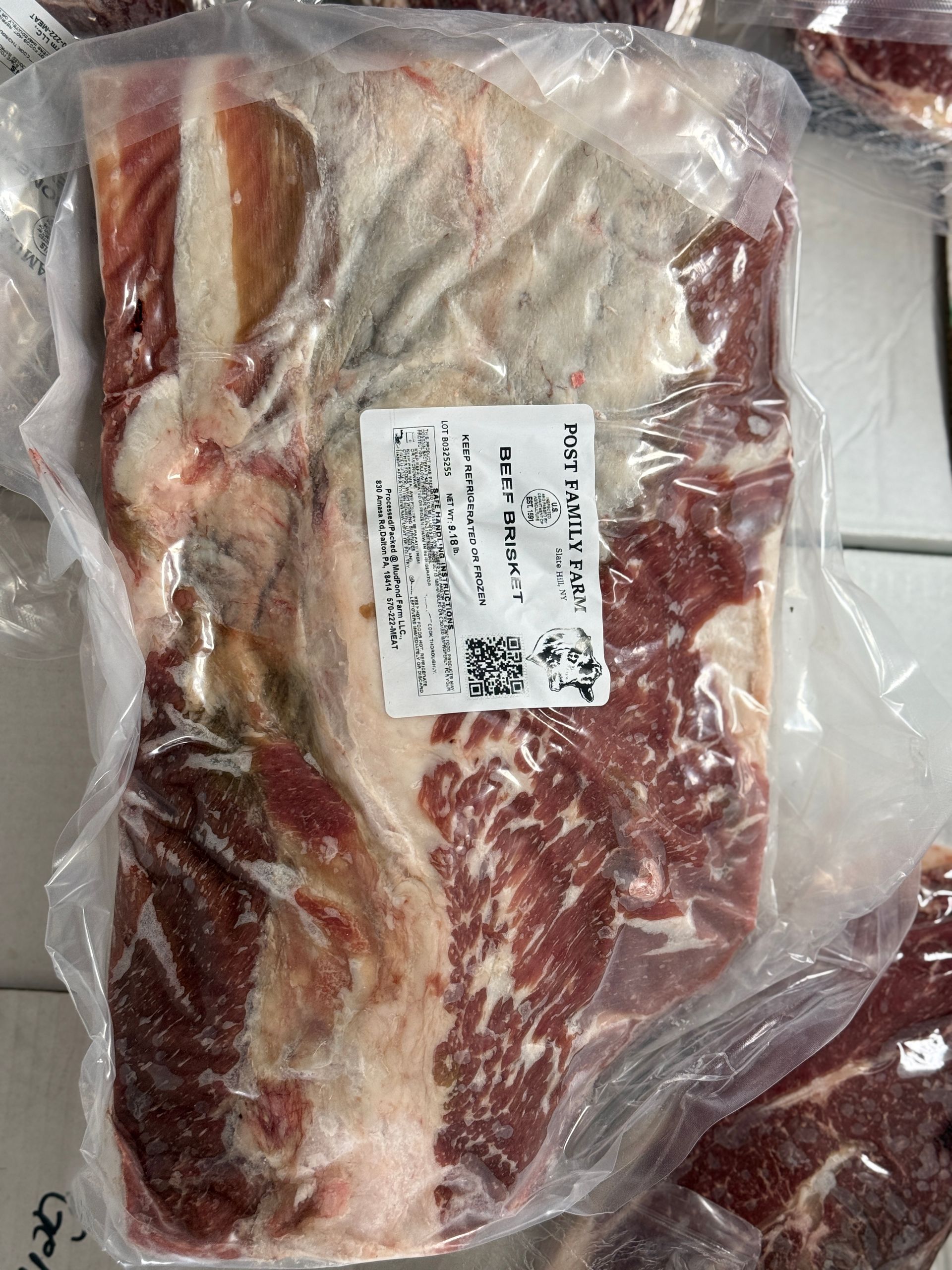 Vacuum-sealed package of raw beef with visible marbling and a white label.