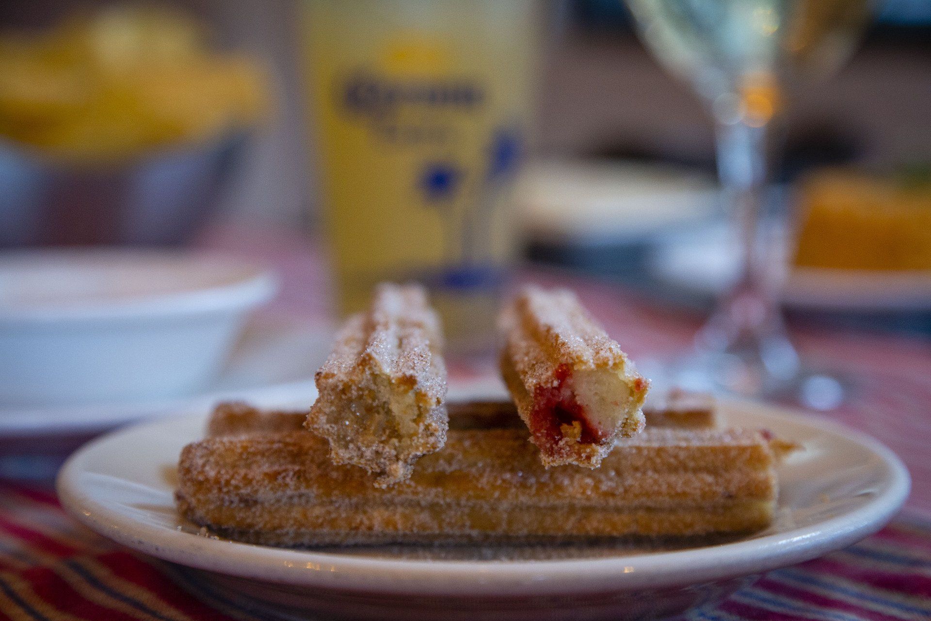 A close up of a plate of churros on a table.