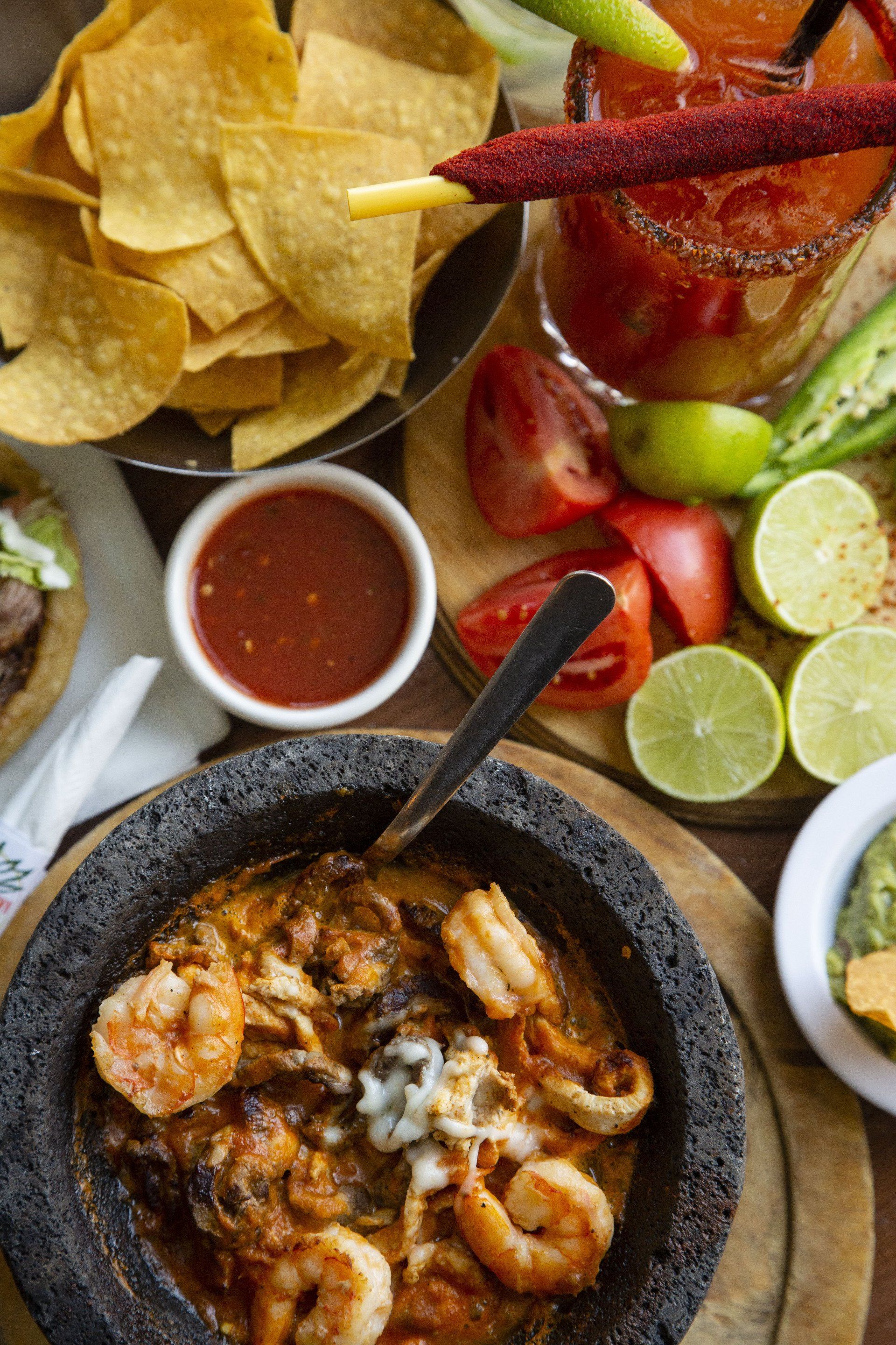 There is a bowl of shrimp in the middle of the table.