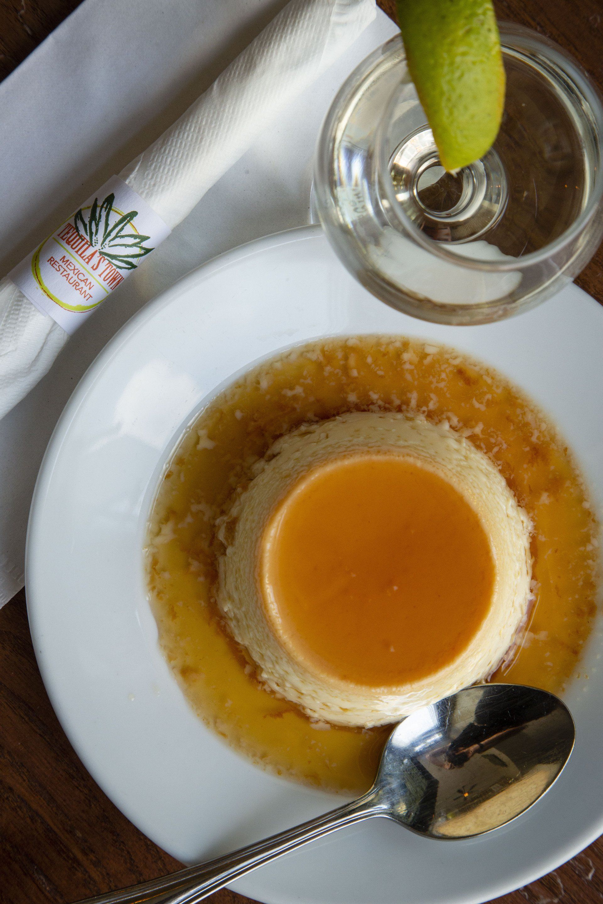 A plate of food with a spoon and a glass of water on a table.