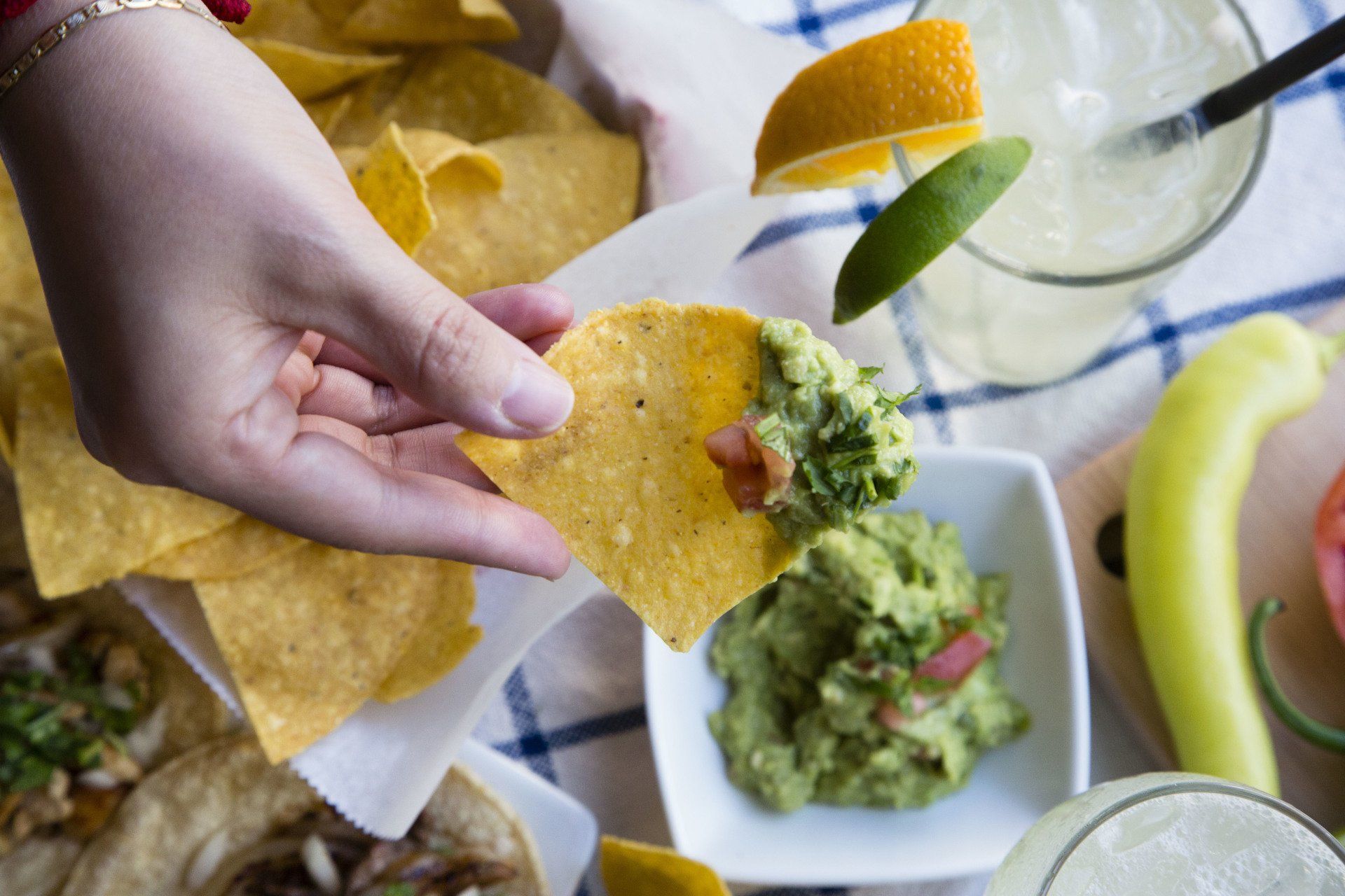 A person is dipping a tortilla chip in guacamole.