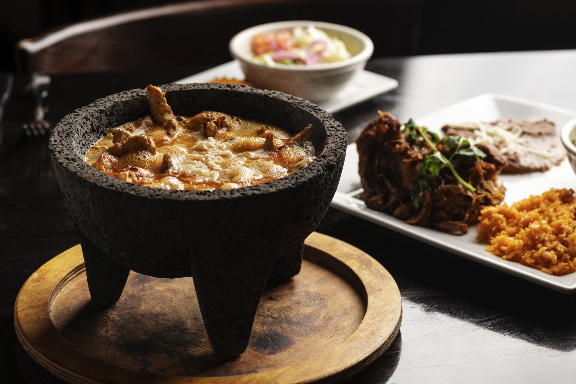 A bowl of food is sitting on a table next to a plate of food.