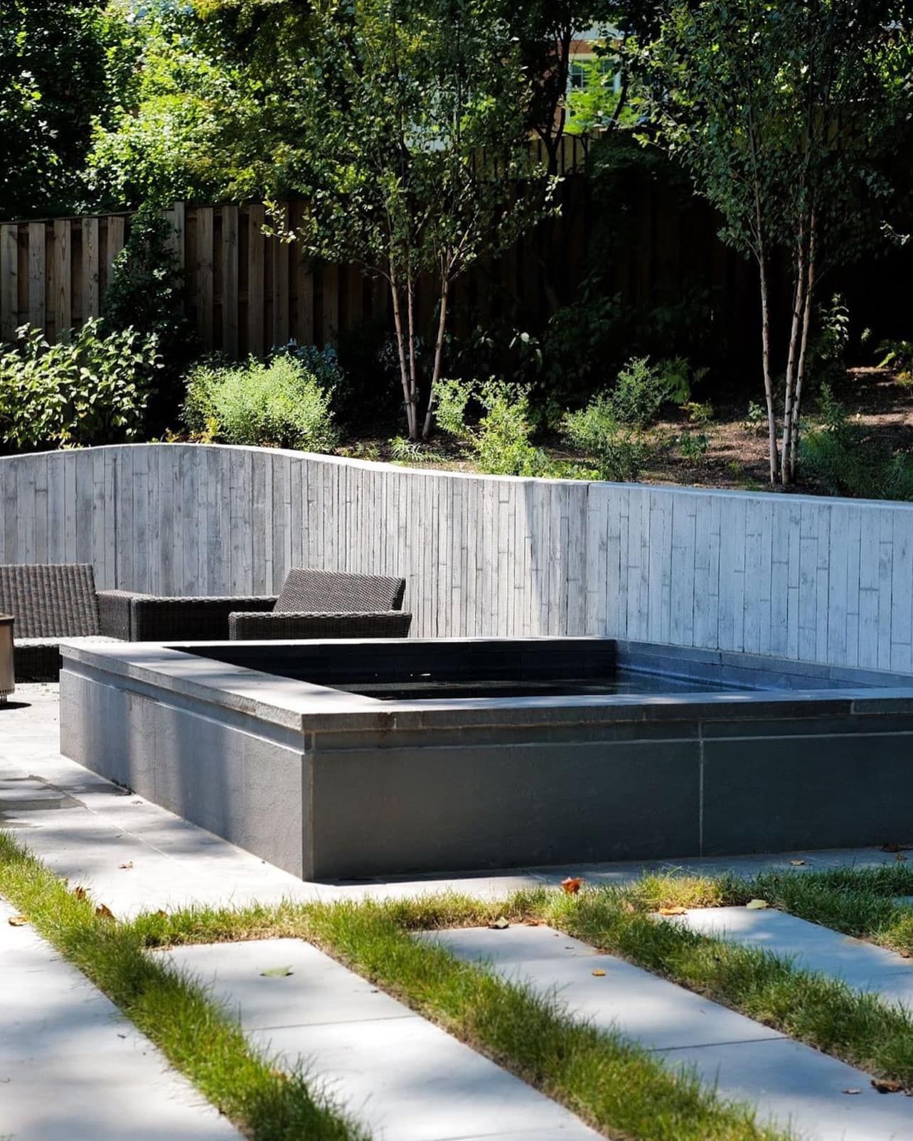 A patio with a fire pit and a fence in the background