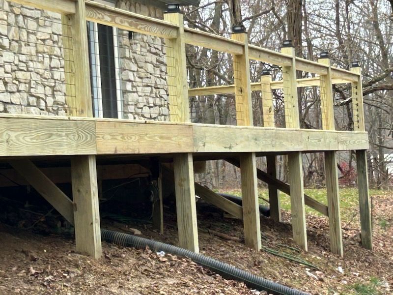 A white house with a black roof and a black garage door.