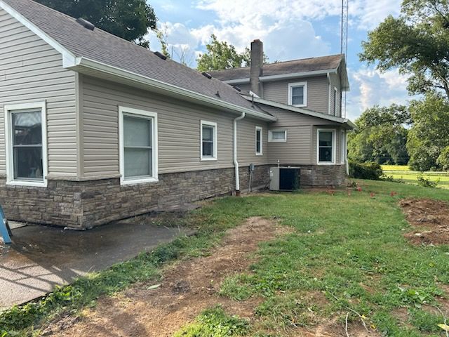 A house with a lot of windows and a lot of grass in front of it.