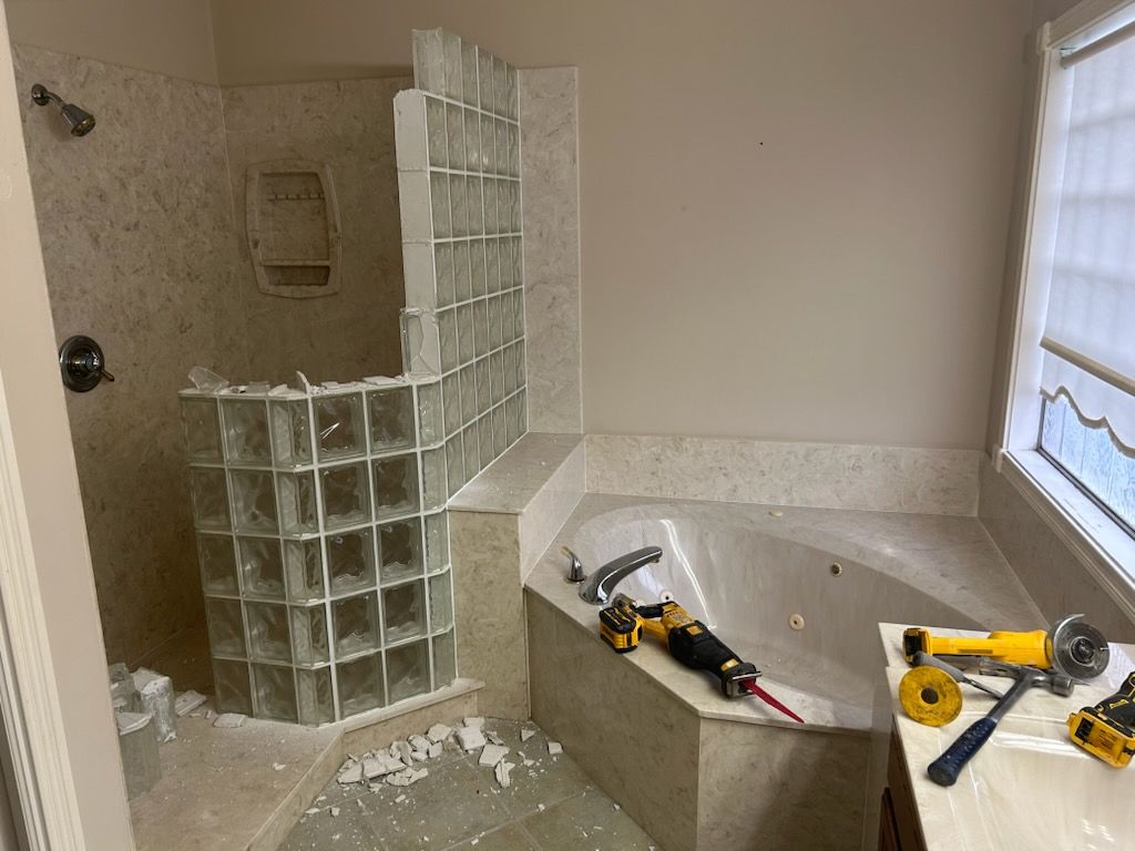 A bathroom with a tub , shower and a window.