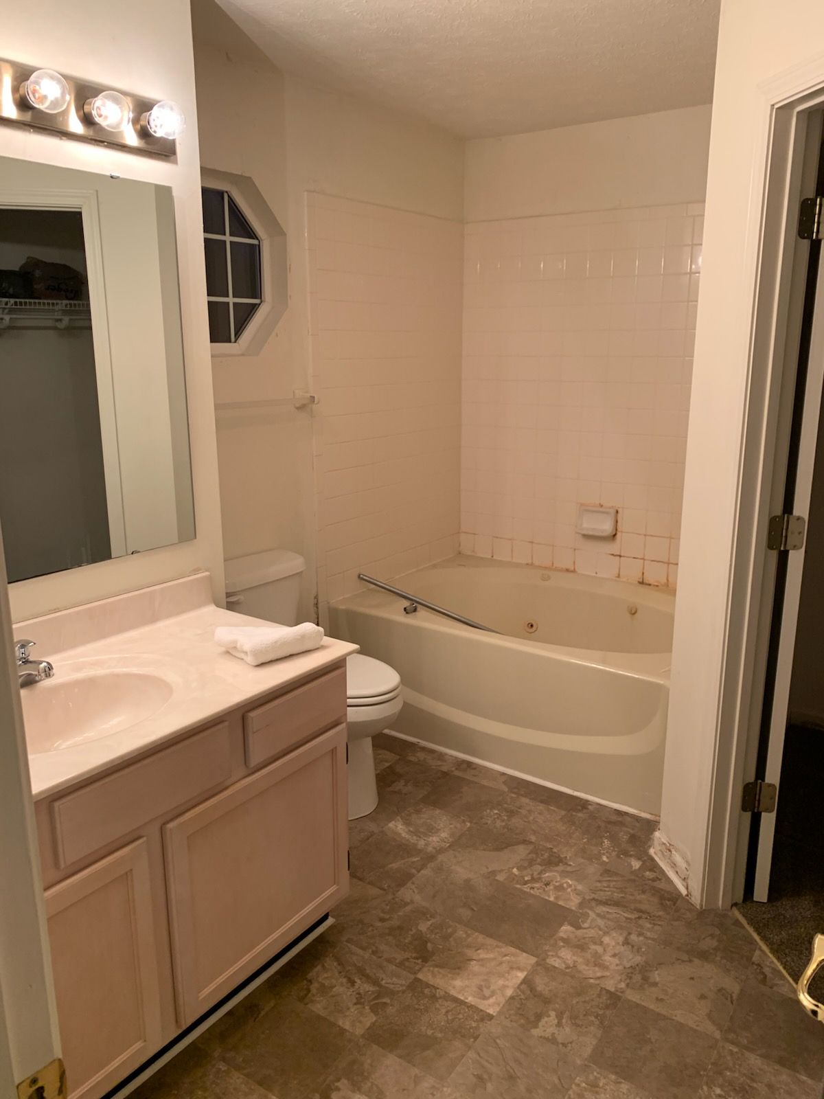 A bathroom with a sink , toilet , tub and mirror