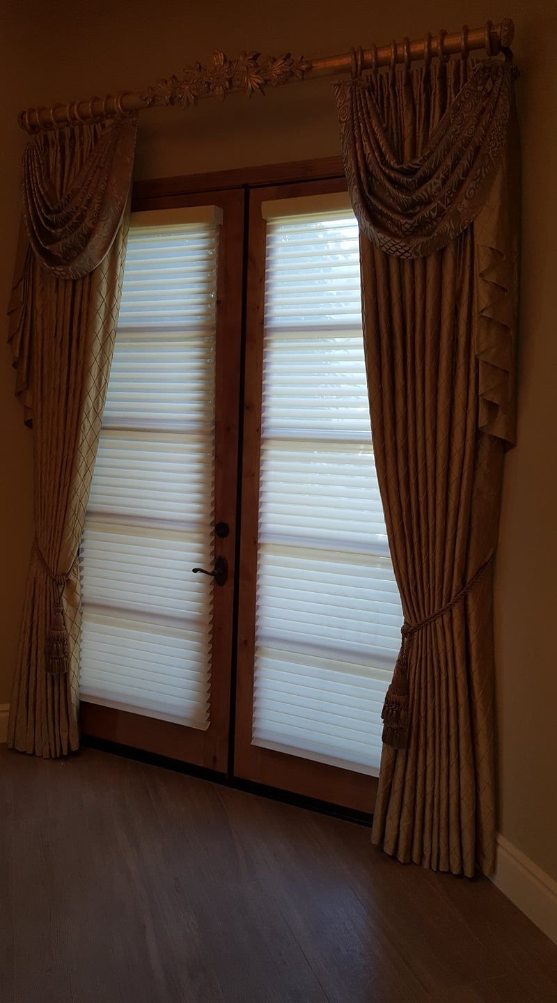 A room with sliding glass doors and curtains on them.