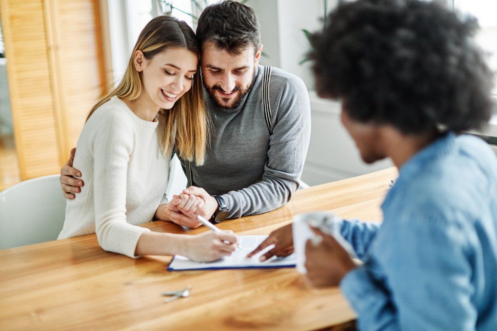 woman signing a paper with her partner