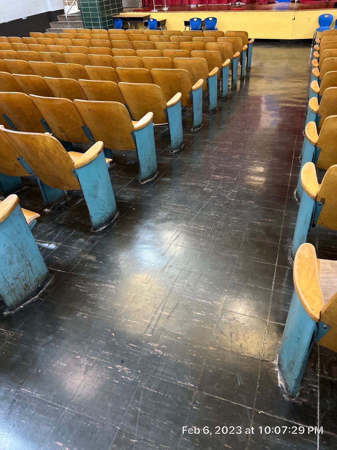 Rows of wooden auditorium seats are lined up in an auditorium.