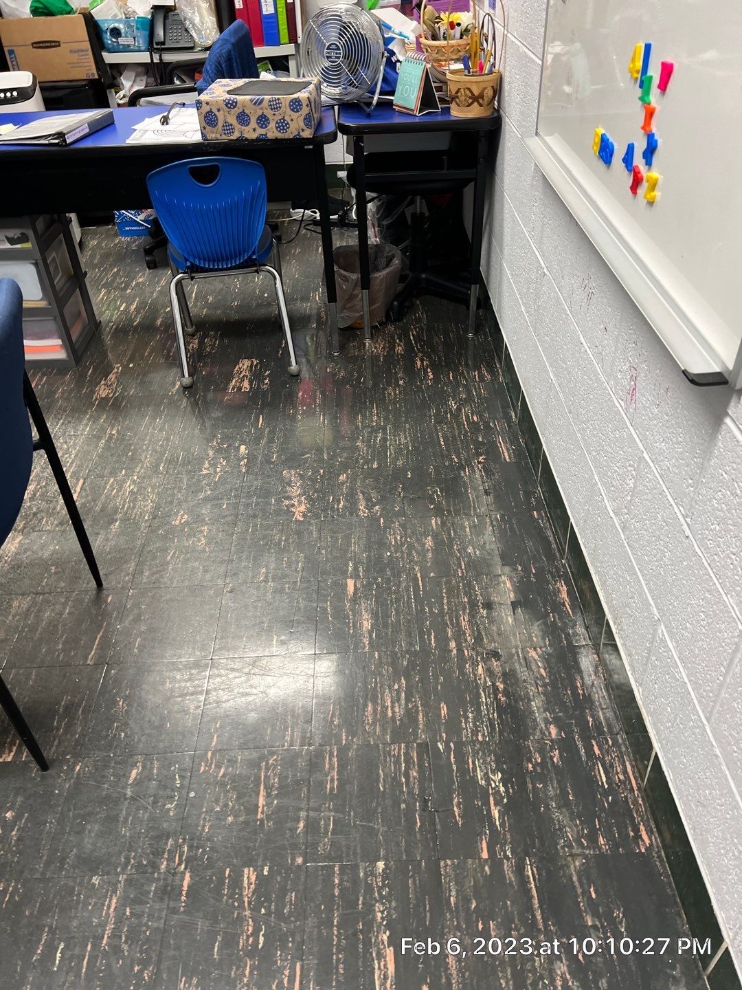 A classroom with a black floor and a white board.