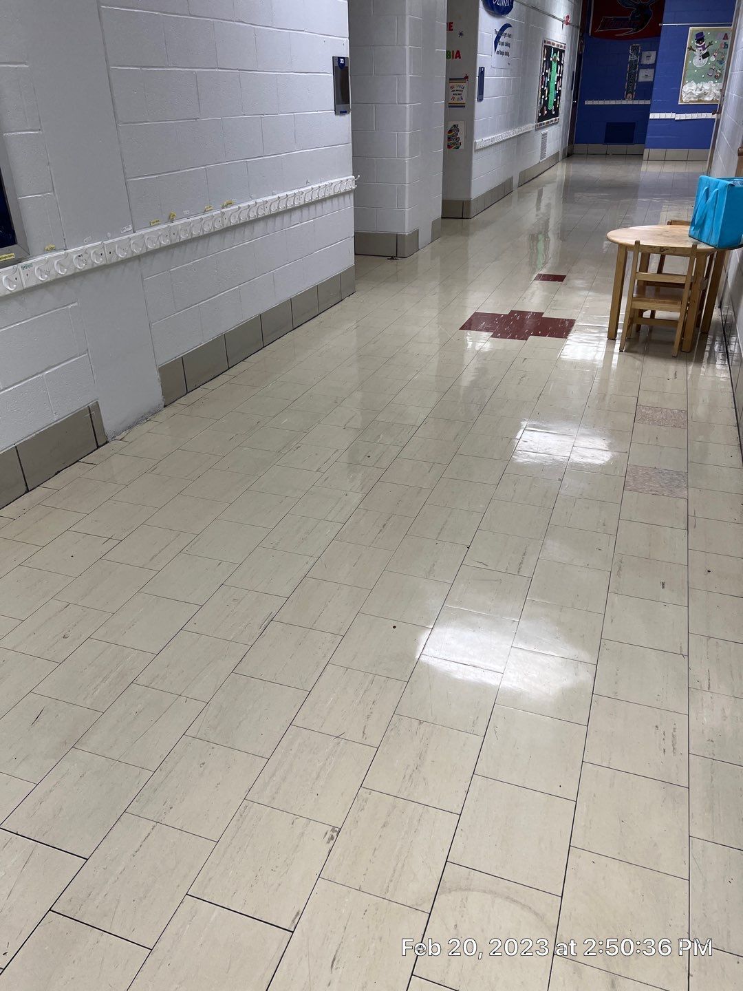 A long hallway with a table and chairs in the middle of it.