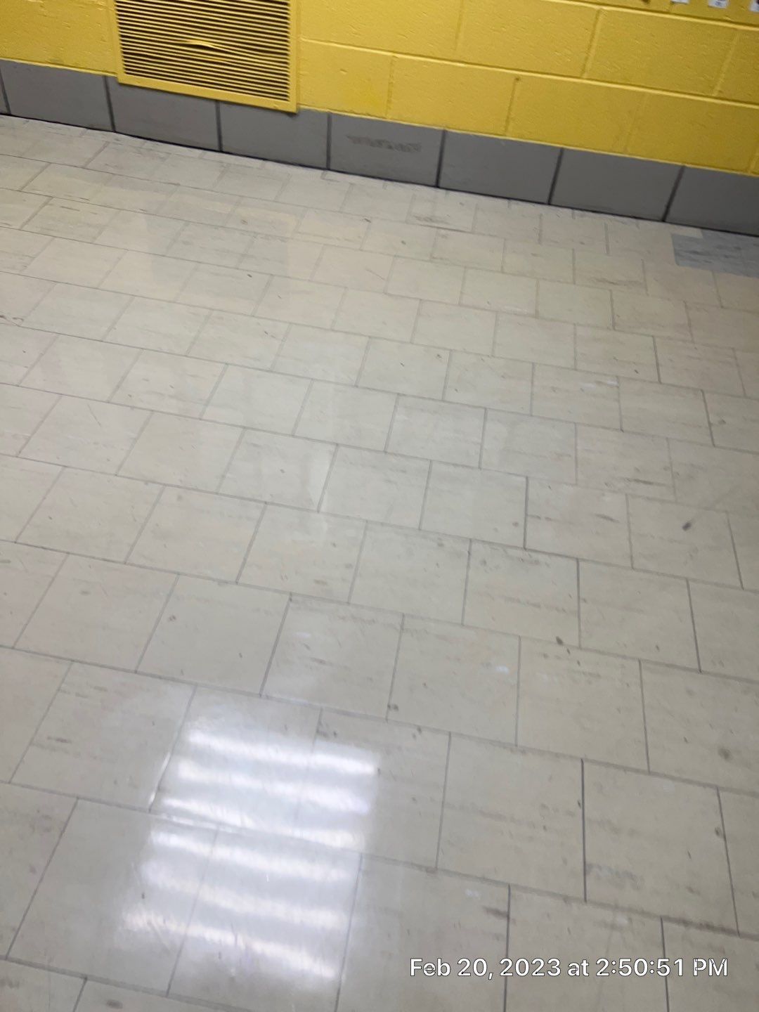 A tiled floor with a yellow wall in the background