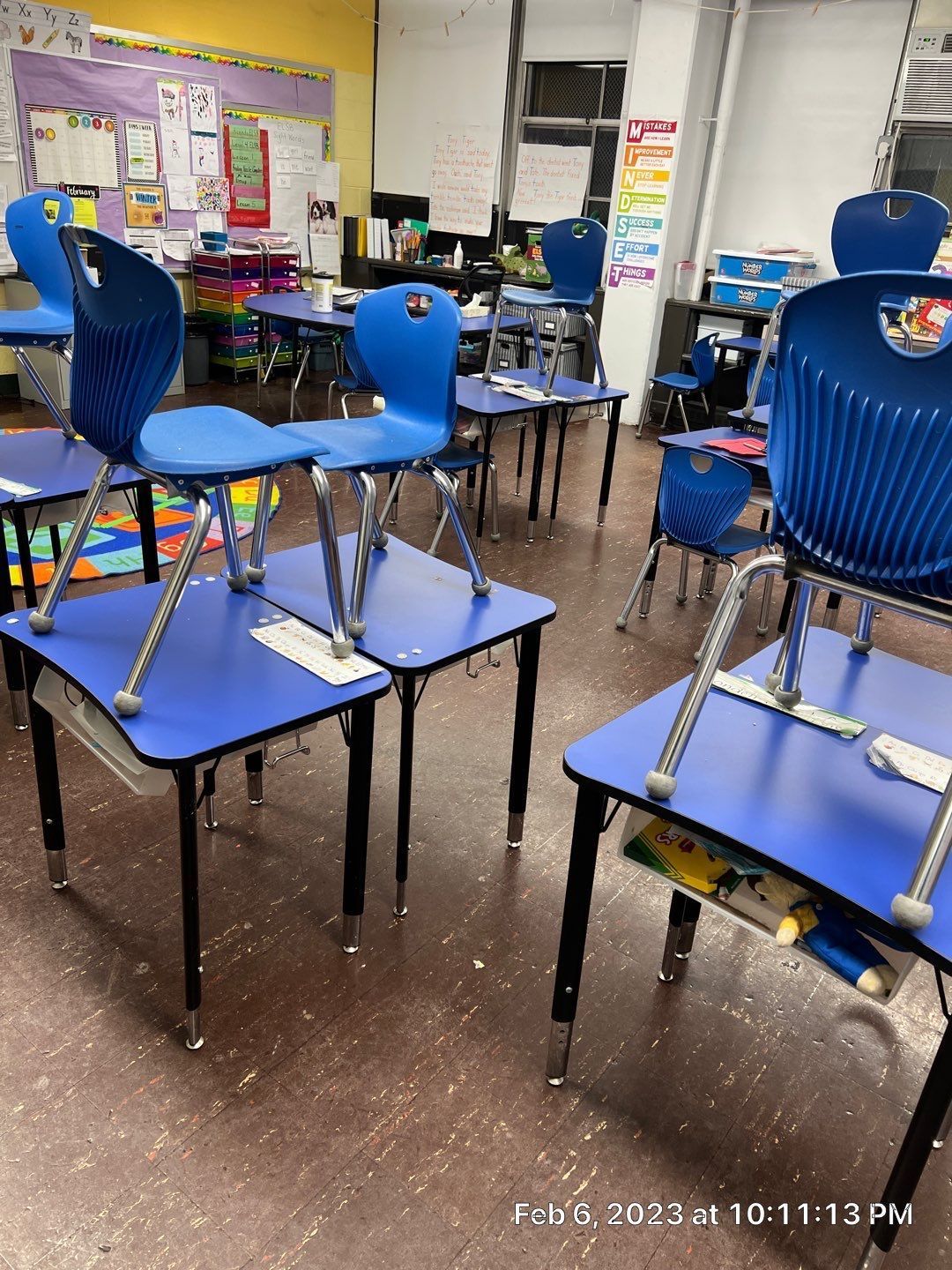 A classroom with blue desks and blue chairs.