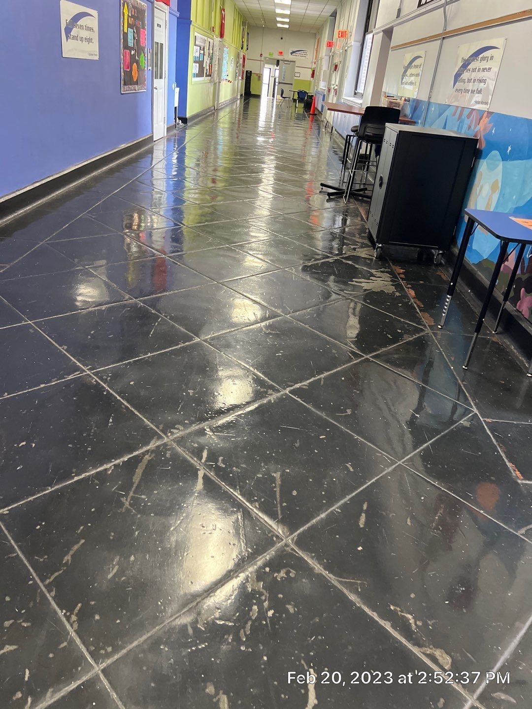 A long hallway with a black tile floor
