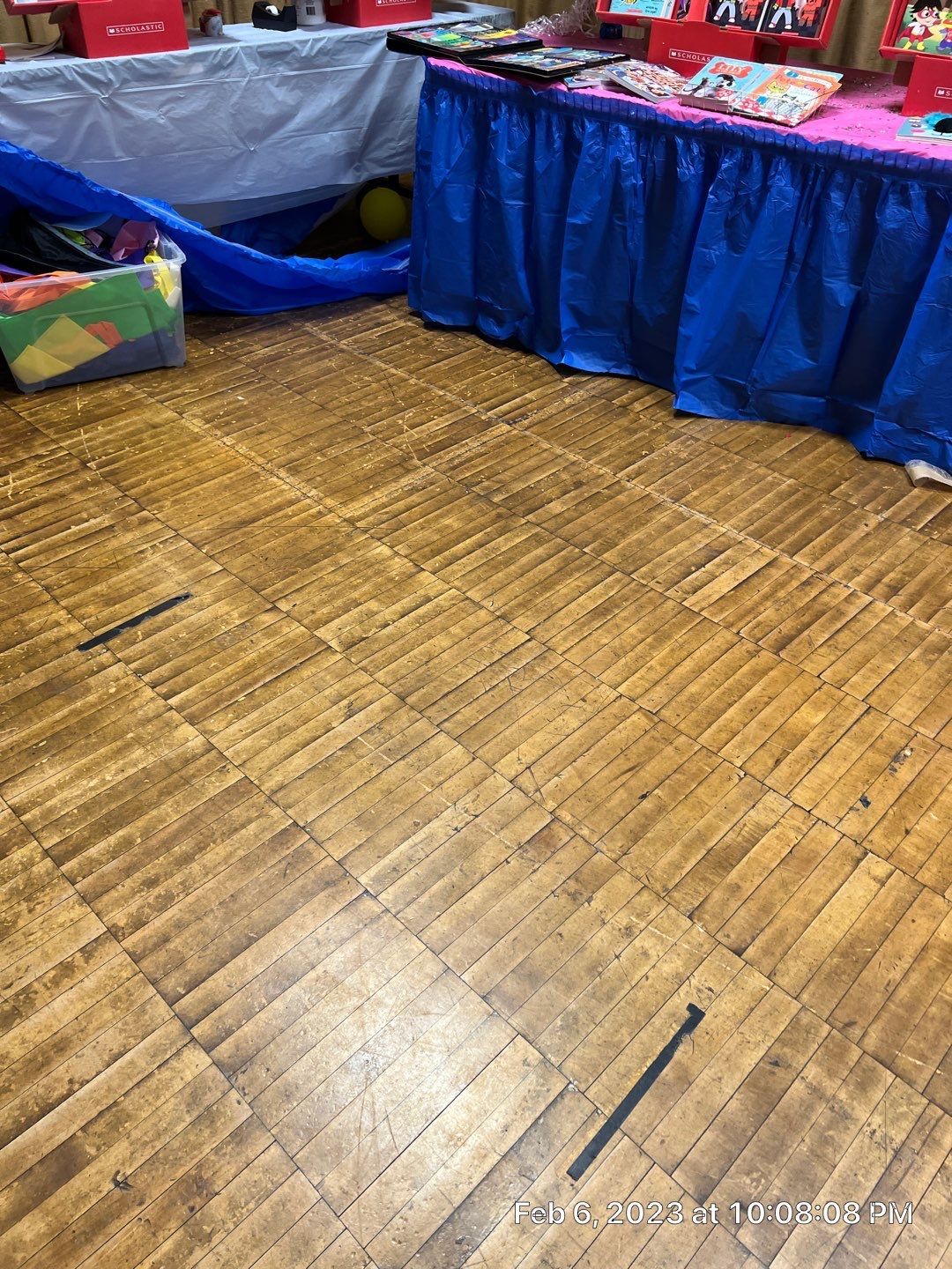 A wooden floor with a blue table cloth on it.